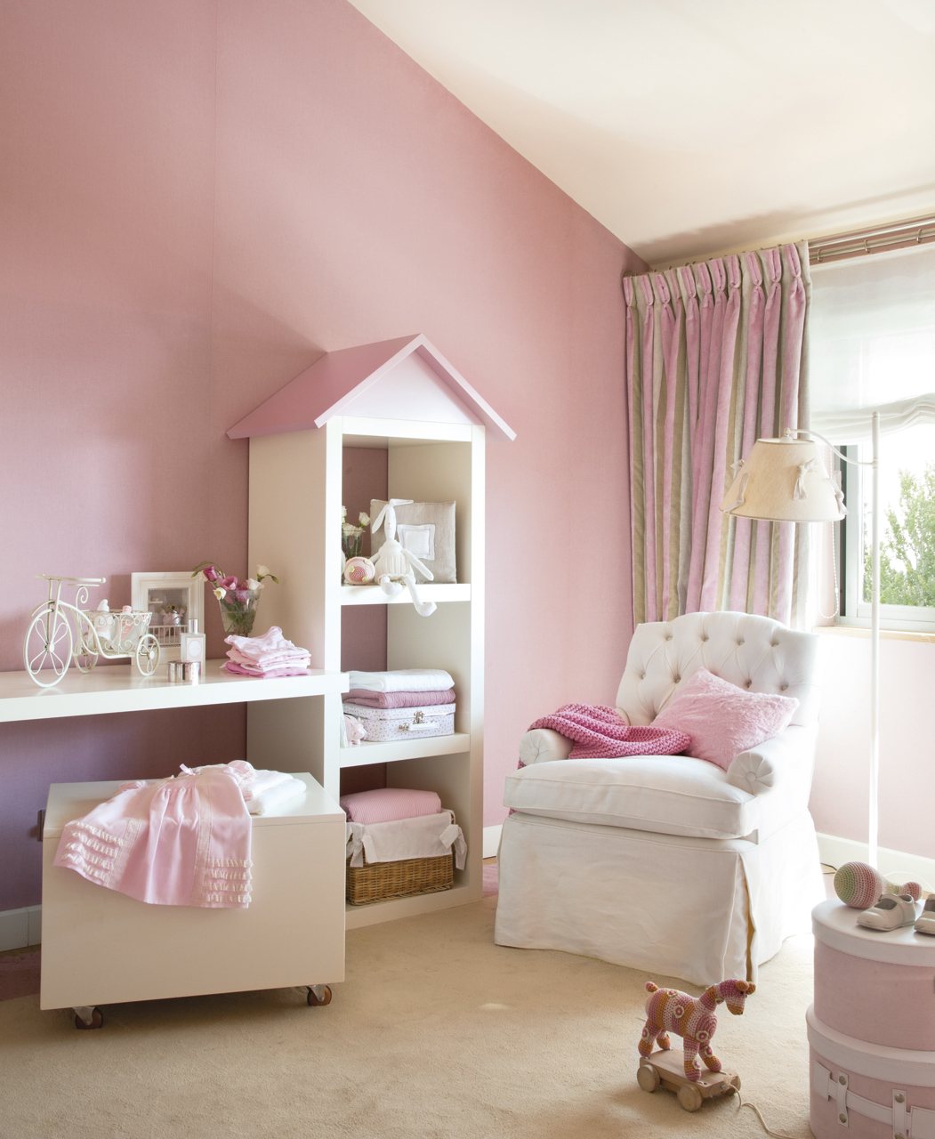 Zona con butaca y almacenaje. Dormitorio infantil blanco y rosa con sillÃ³n y estanterÃ­as