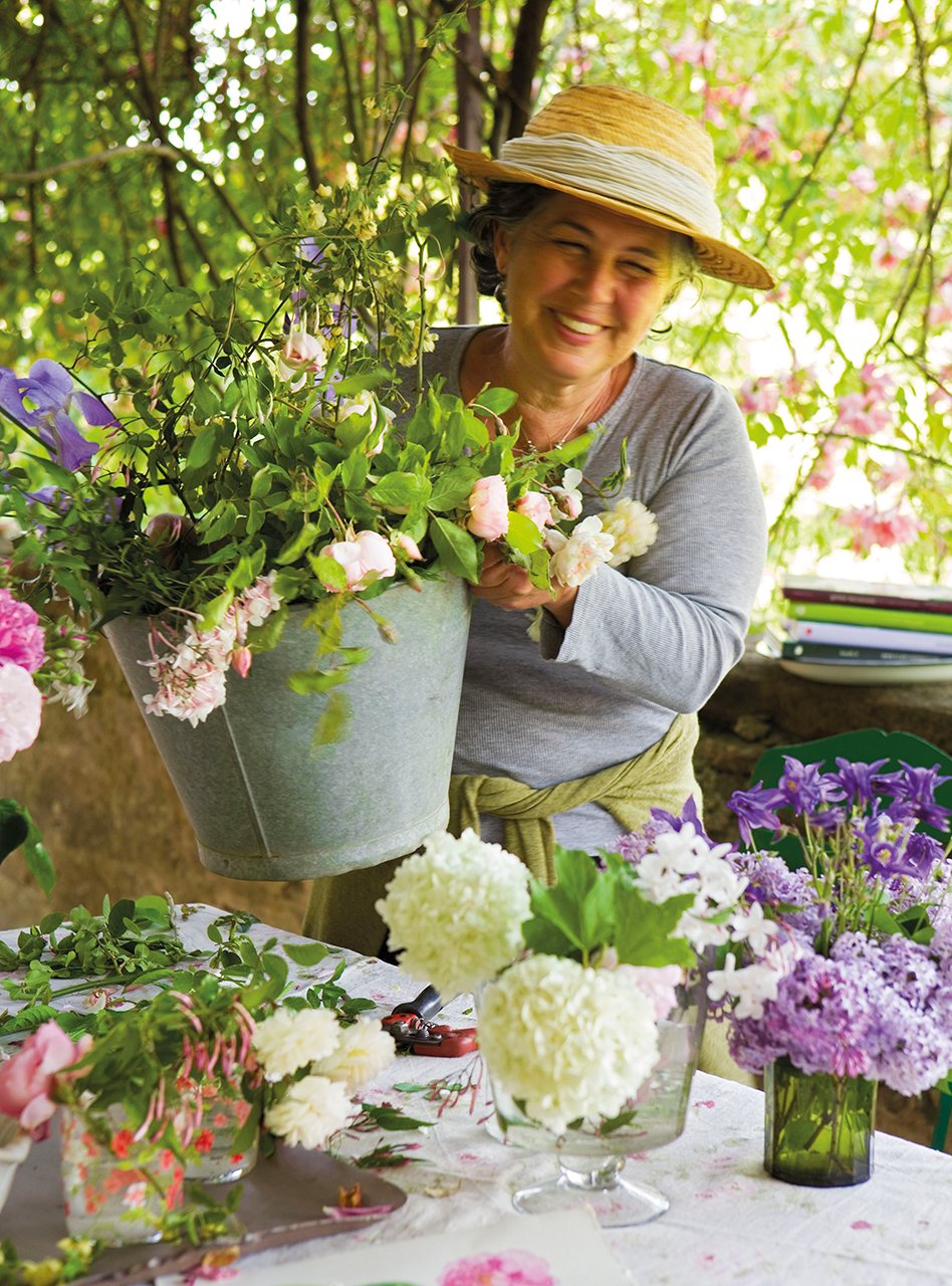 Mujer recogiendo sus plantas y poniéndolas sobre una mesa