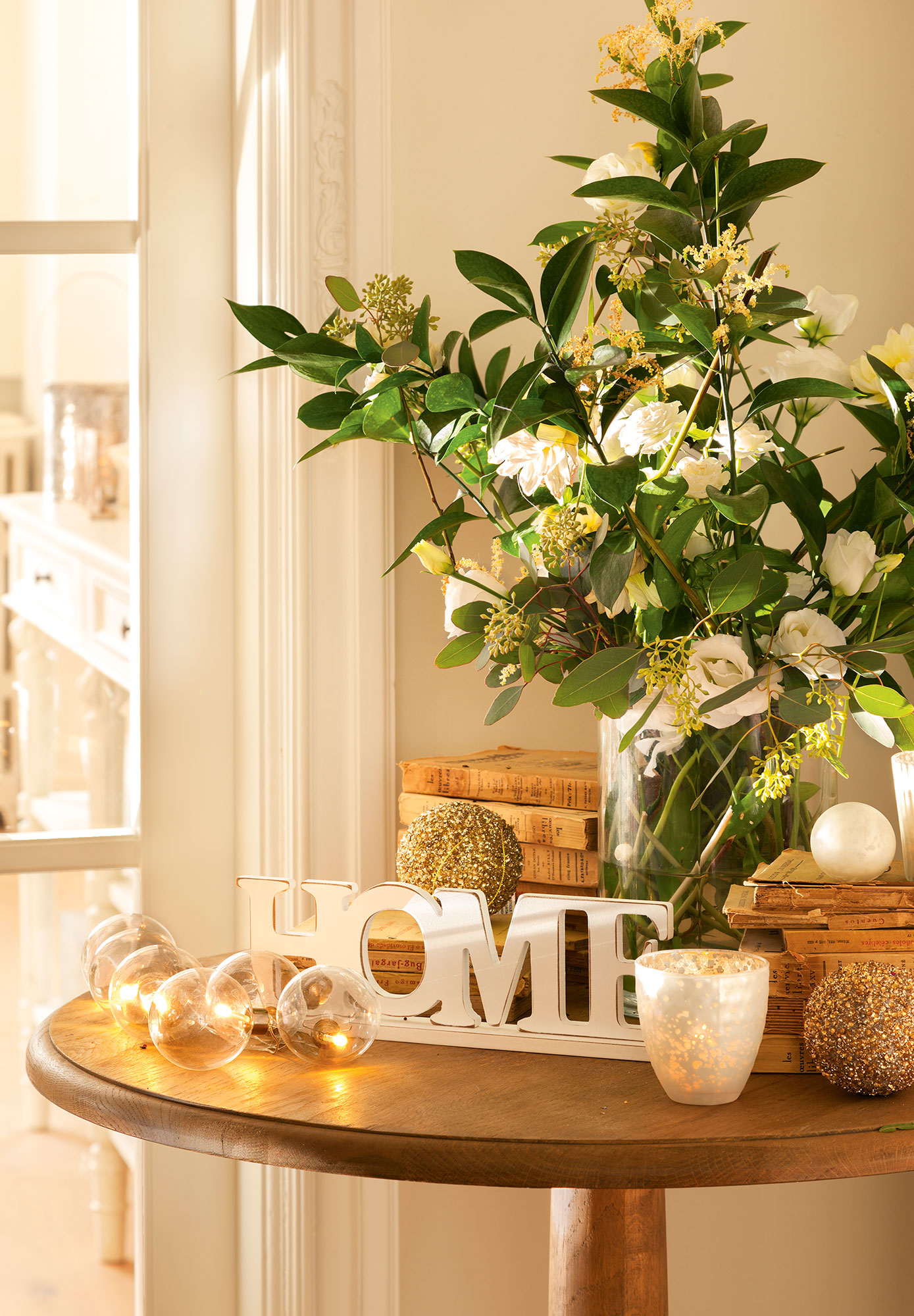 Detalle de rincón del salón con composición floral y detalles navideños en blanco y dorado 