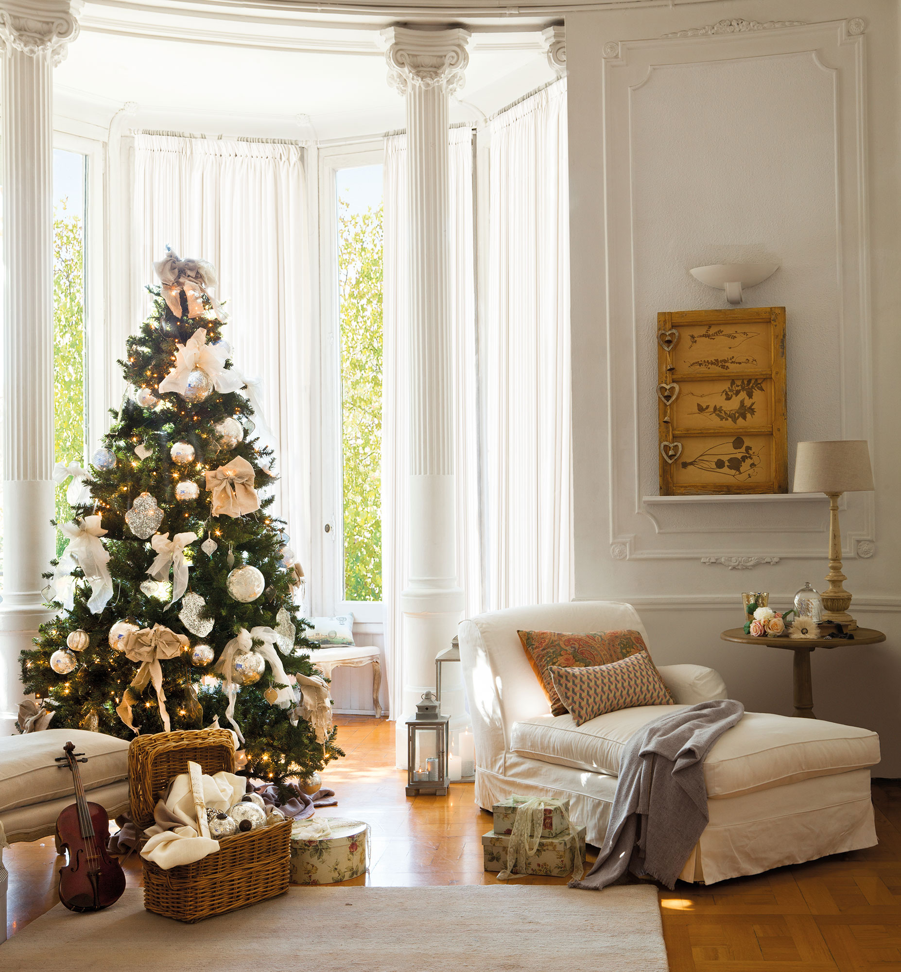 Rincón del árbol de Navidad en salón clásico decorado en blanco y dorado