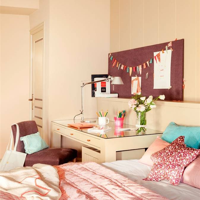 Escritorio de DM lacado a lado de una cama con textiles de color rosa