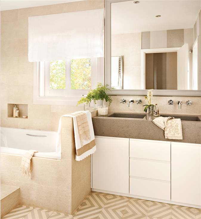 Baño en blanco y beige con lavamanos y mueble, bañera, suelo hidráulico, espejo y ventana