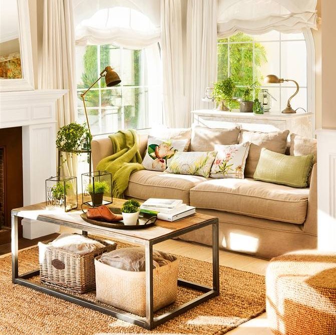Salón con sofá beige, cojines verdes, mesa de centro en madera y metal, lámparas vintage y cortinas y estores blancos