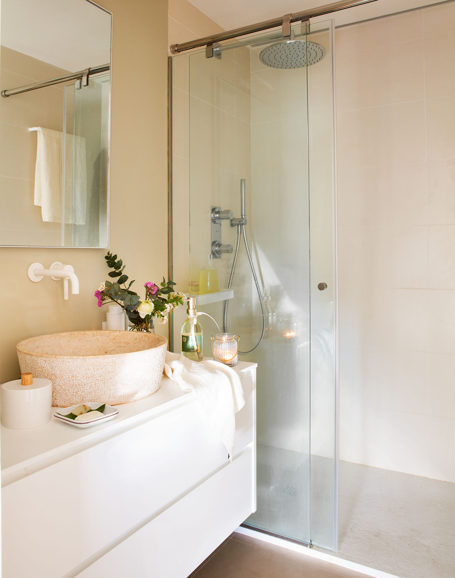 Baño con ducha y mueble de lavabo suspendido de color blanco. 