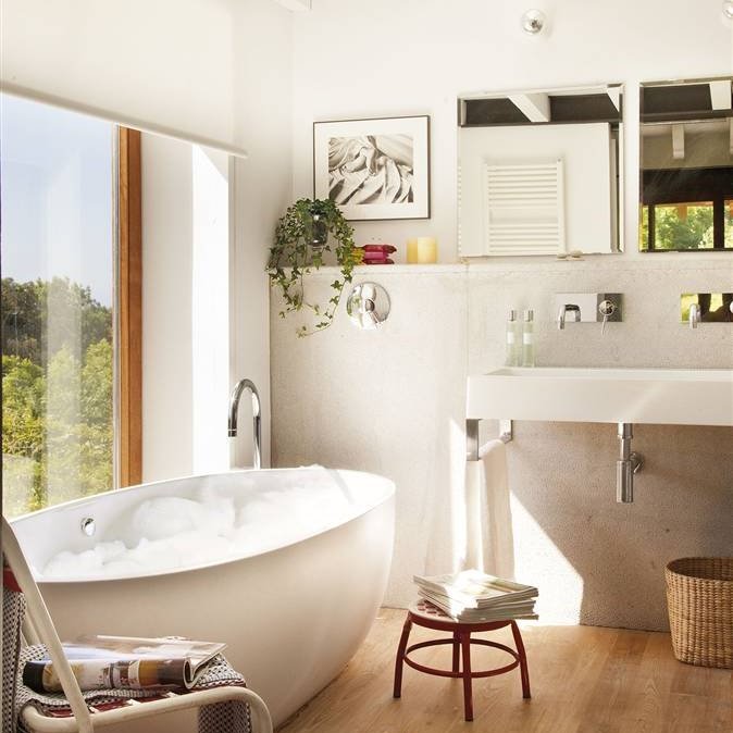 Baño en blanco y suelo de madera con bañera exenta ovalada