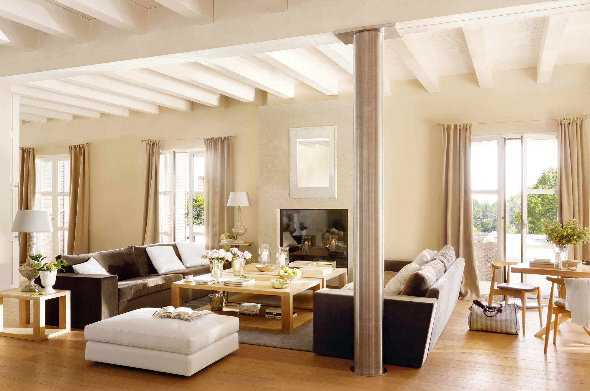 Salón amplio con vigas de madera, sofás modernos y distribución simétrica