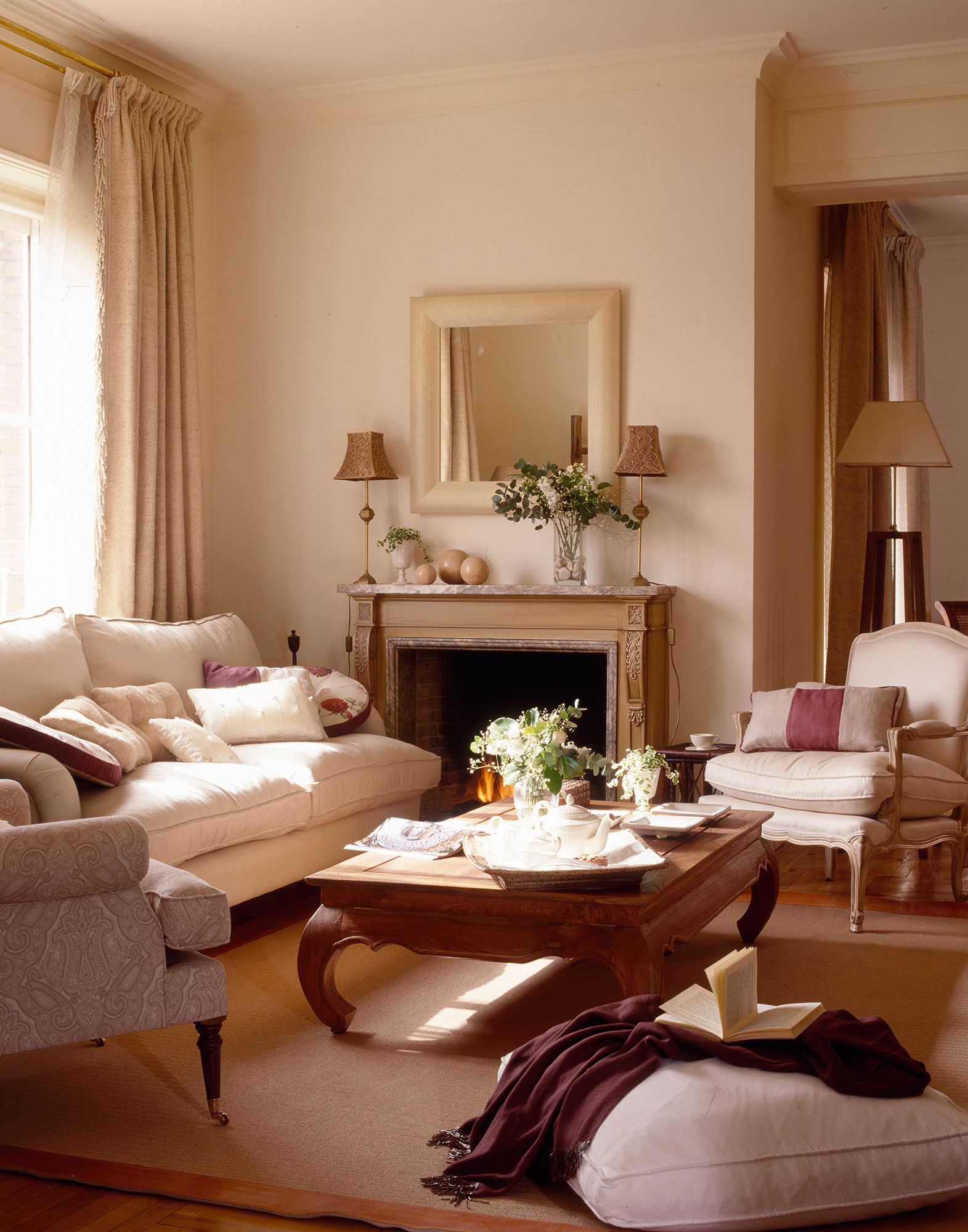 Salón pequeño de estilo clásico con sofás beige y chimenea.