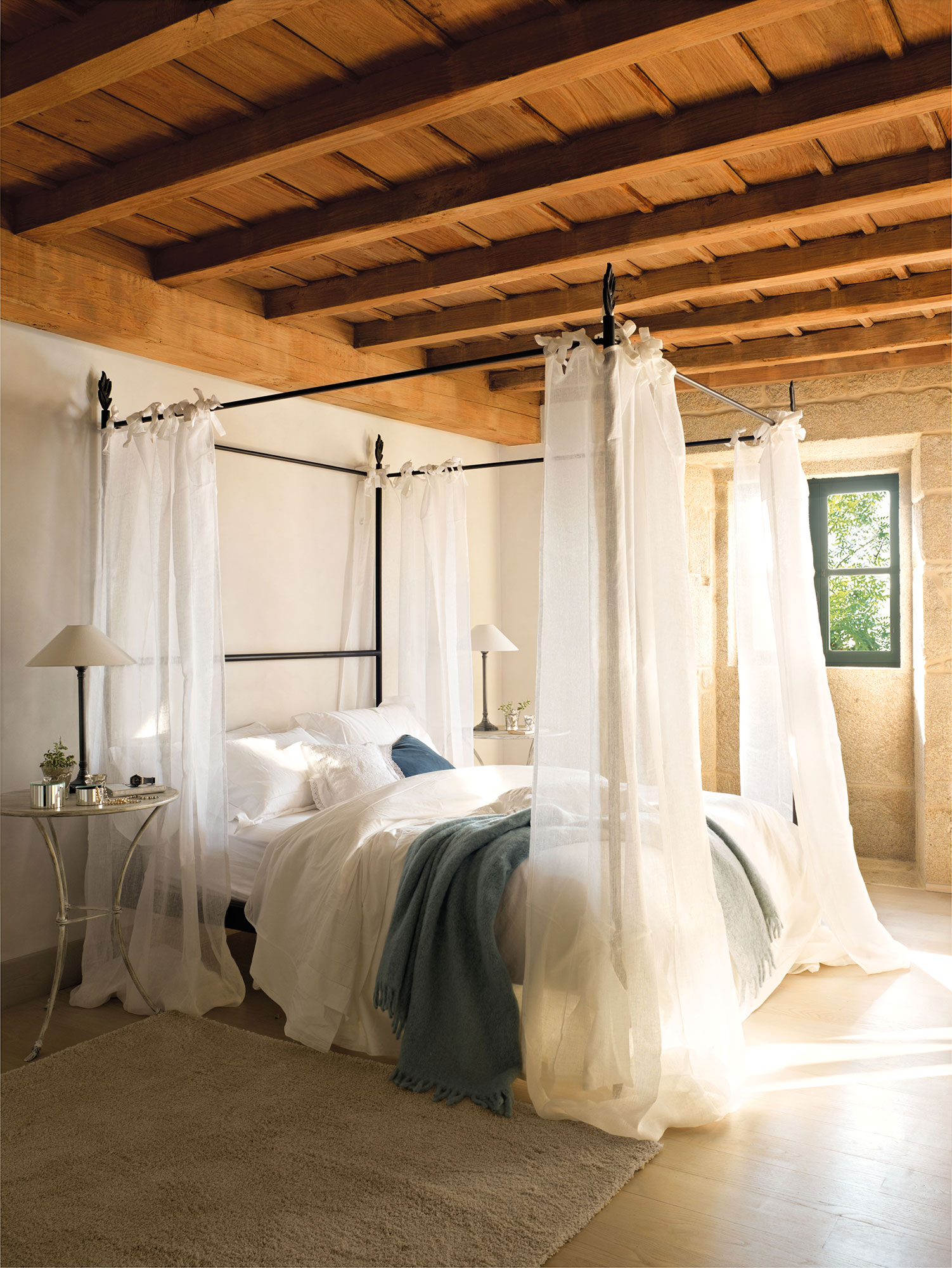 Dormitorio con dosel con cortinas tipo visillo. 