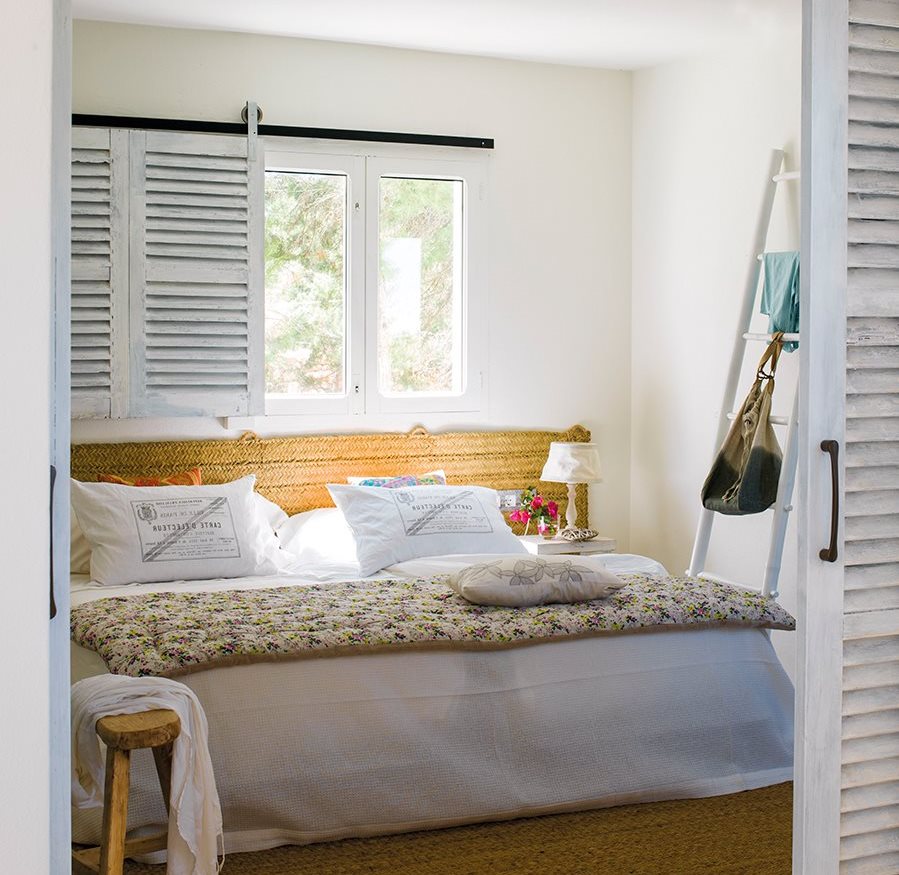 Dormitorio con cabecero y alfombra de esparto