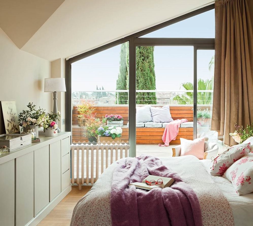 Dormitorio abuhardillado con pared de ventanal