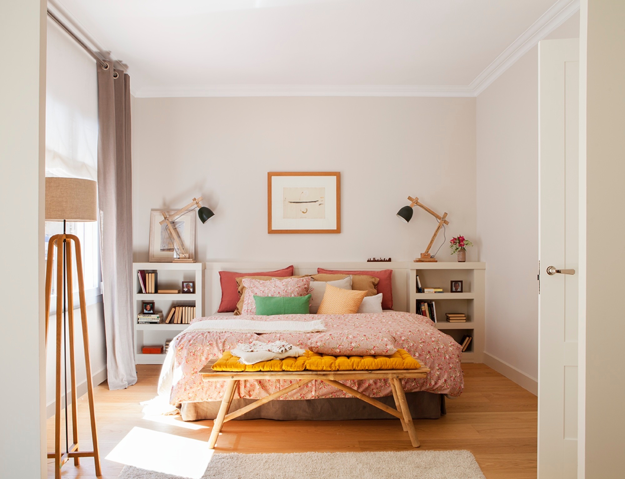 Dormitorio con cabecero de obra y ropa de cama rosa. 