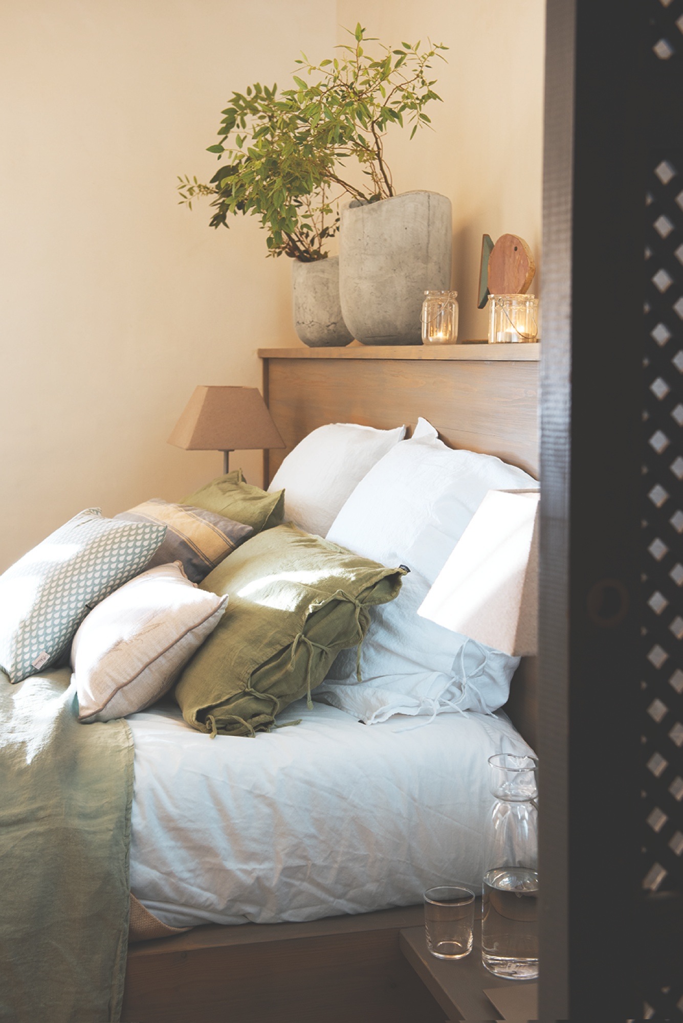 Detalle de dormitorio con cojines de tonos verdes, blancos y azules - 438529