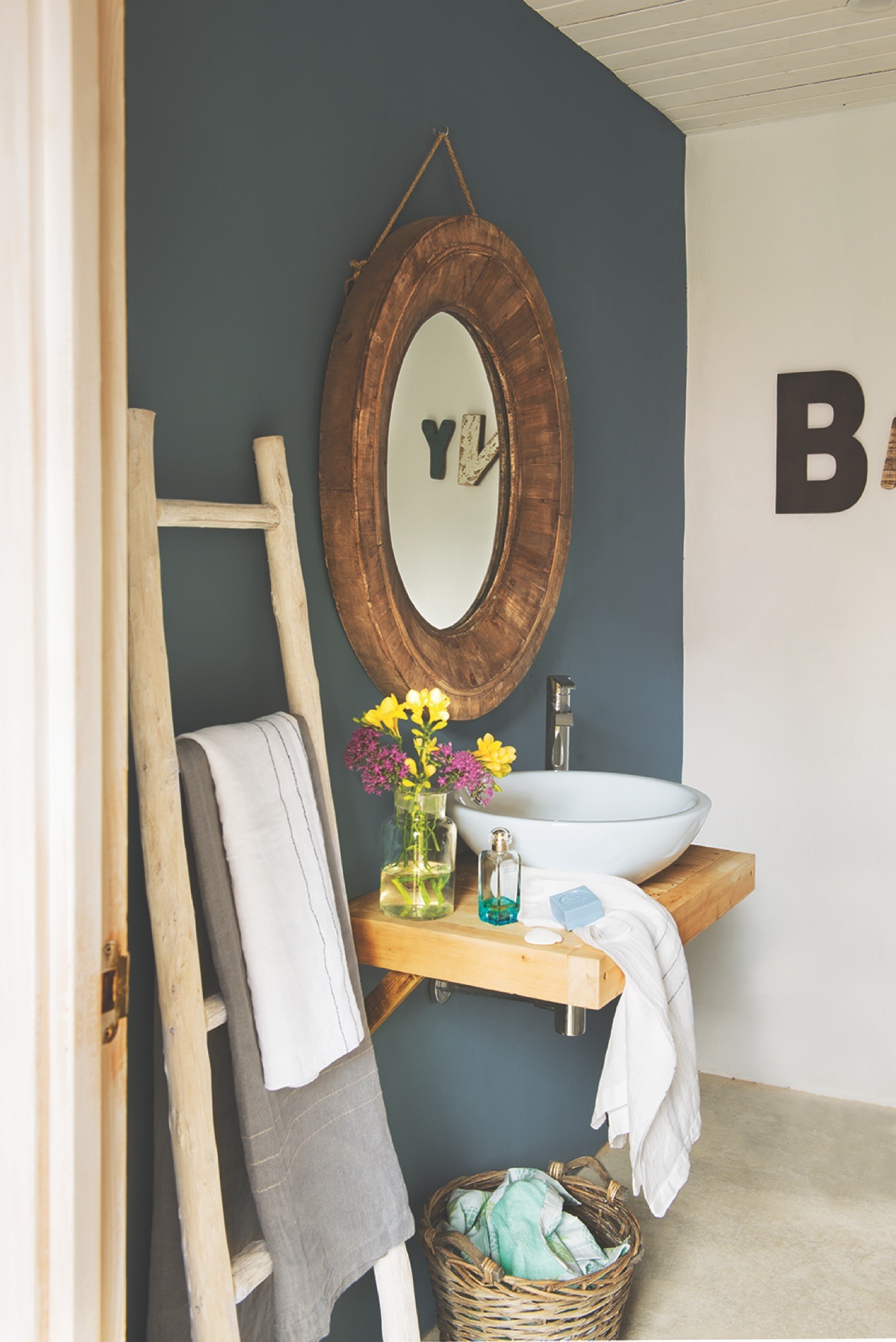 baño con pared azul y espejo redondo - 438528