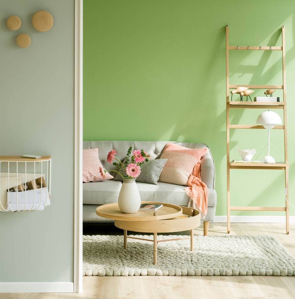 Salón con pared verde y gris y parquet de madera clara_421417 O