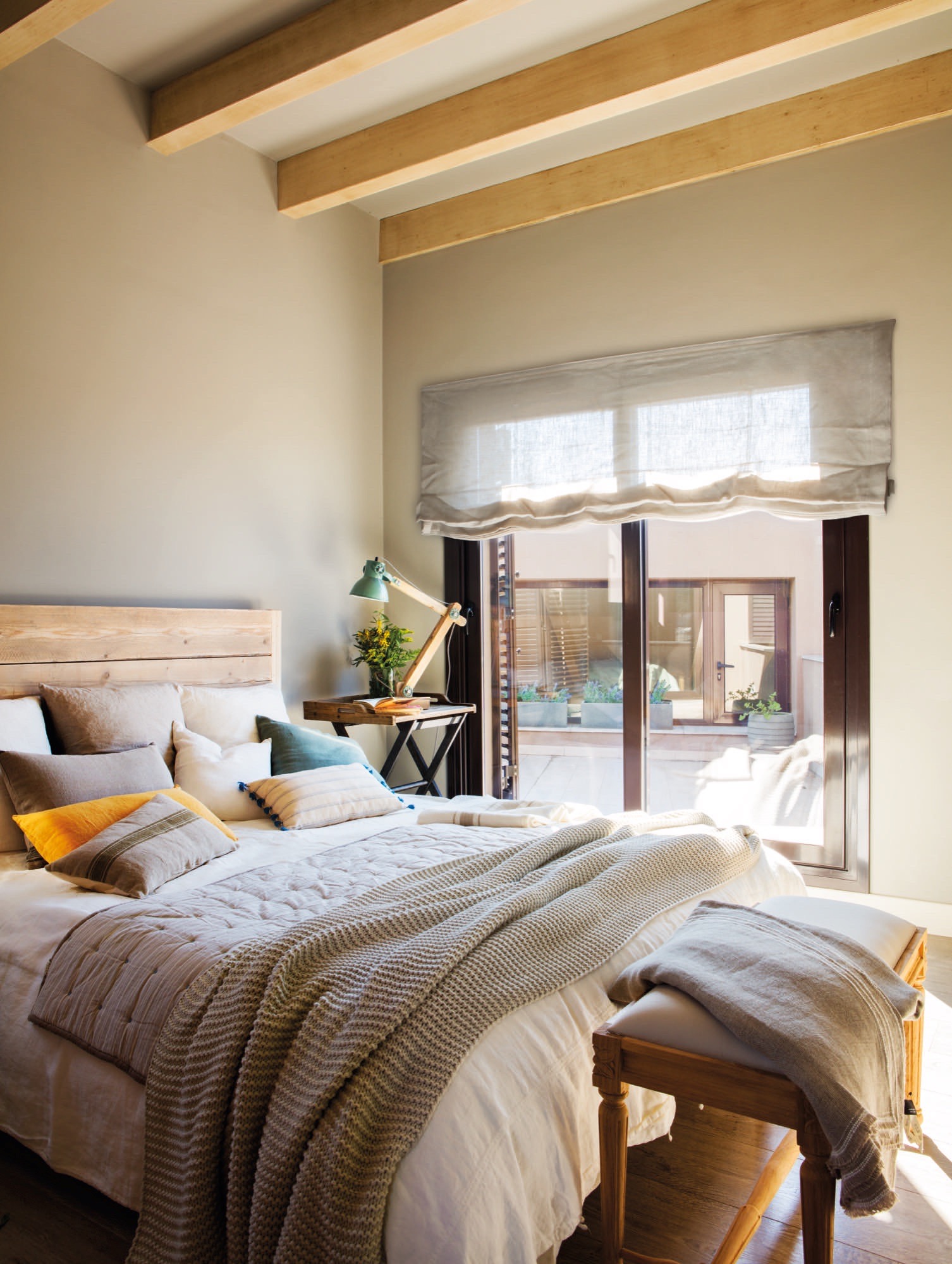 Dormitorio principal con cabecero de madera. 