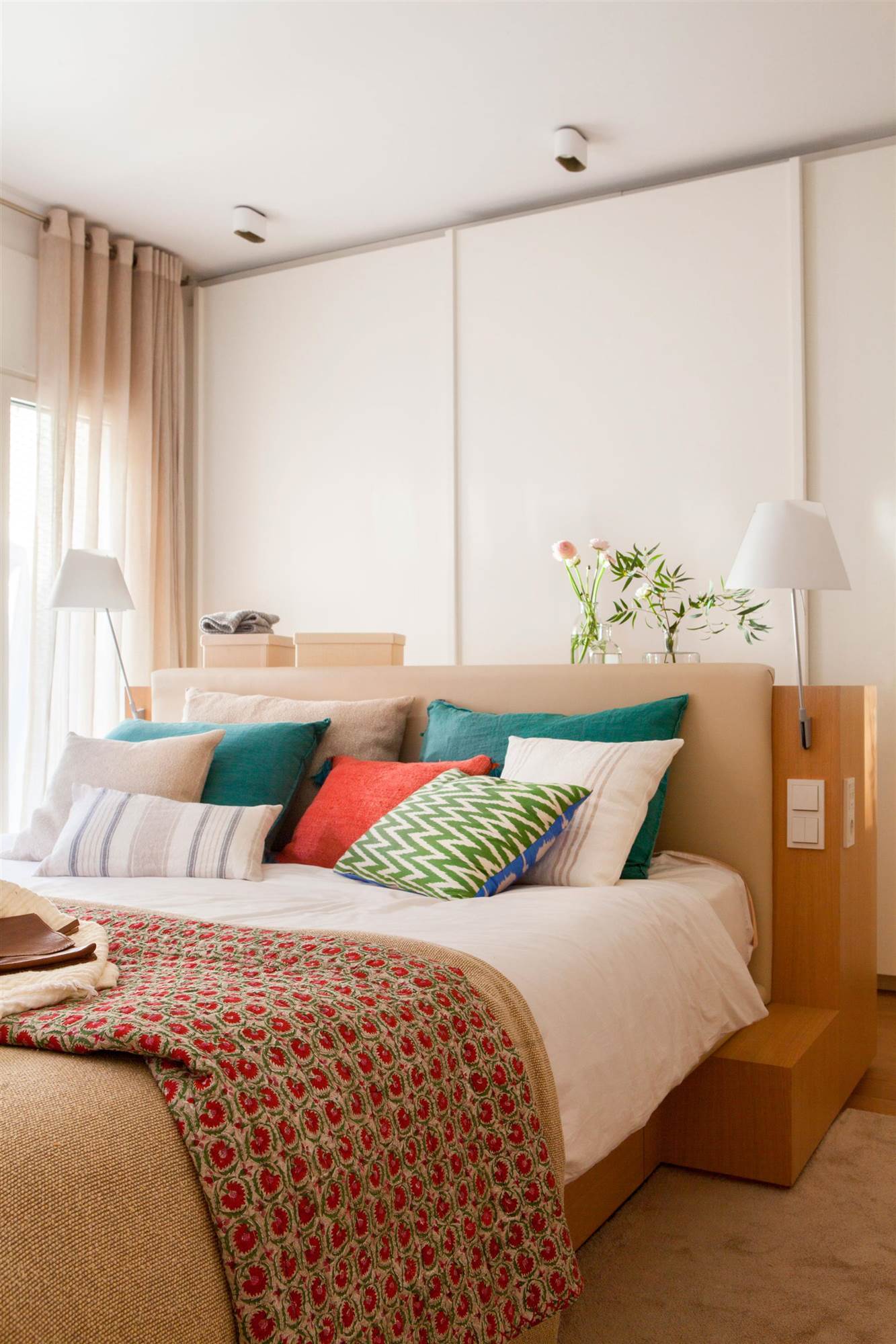 Dormitorio con cabecero de madera que hace de separación del armario corredero