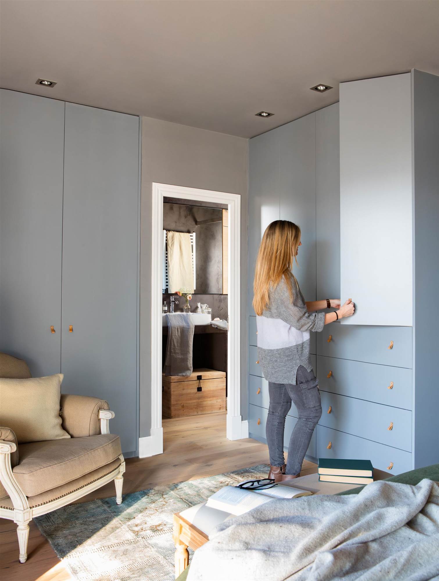 Dormitorio con armarios de color gris y mujer