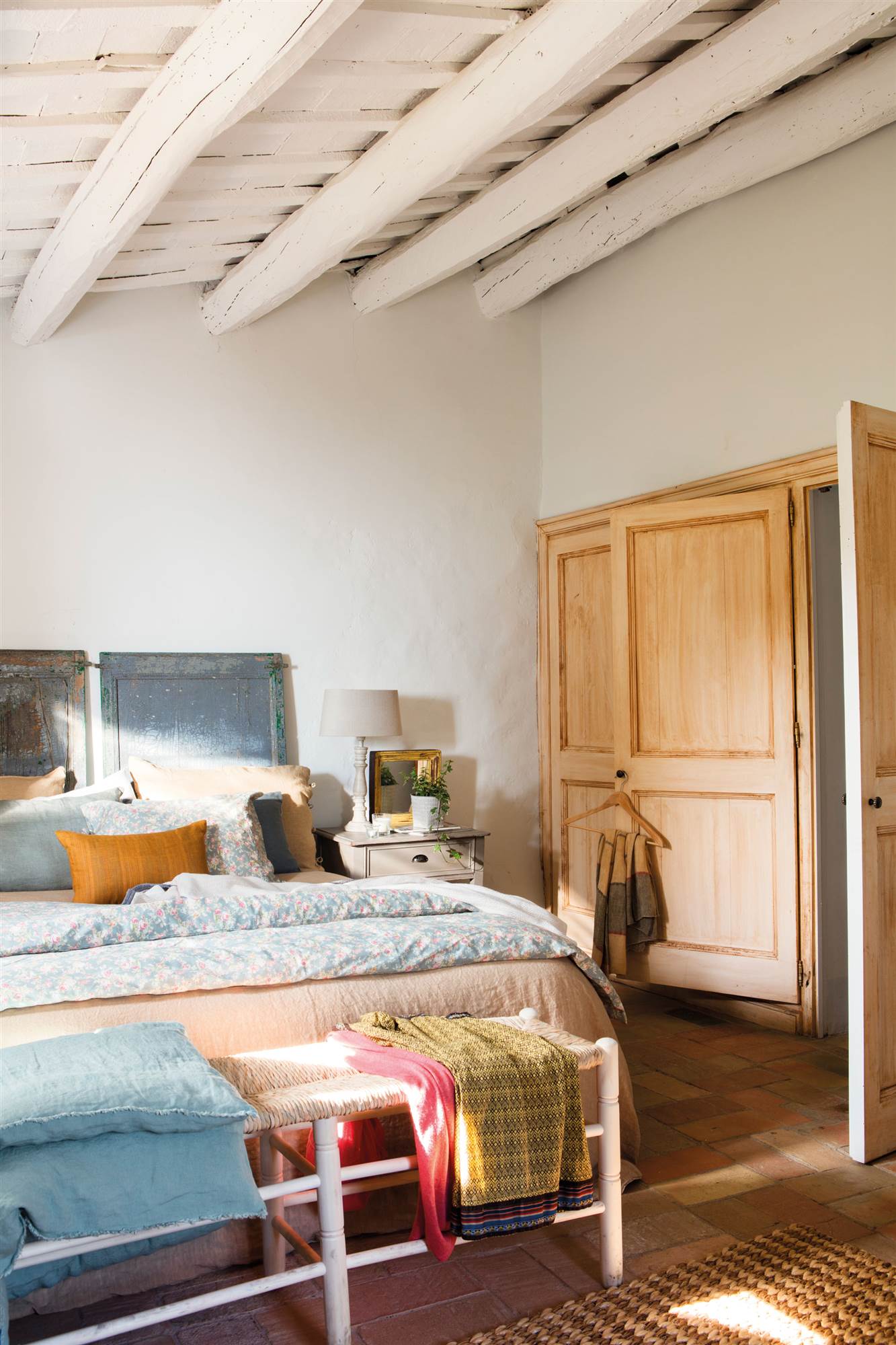 Dormitorio rústico con armario con frentes de madera idénticos a la puerta