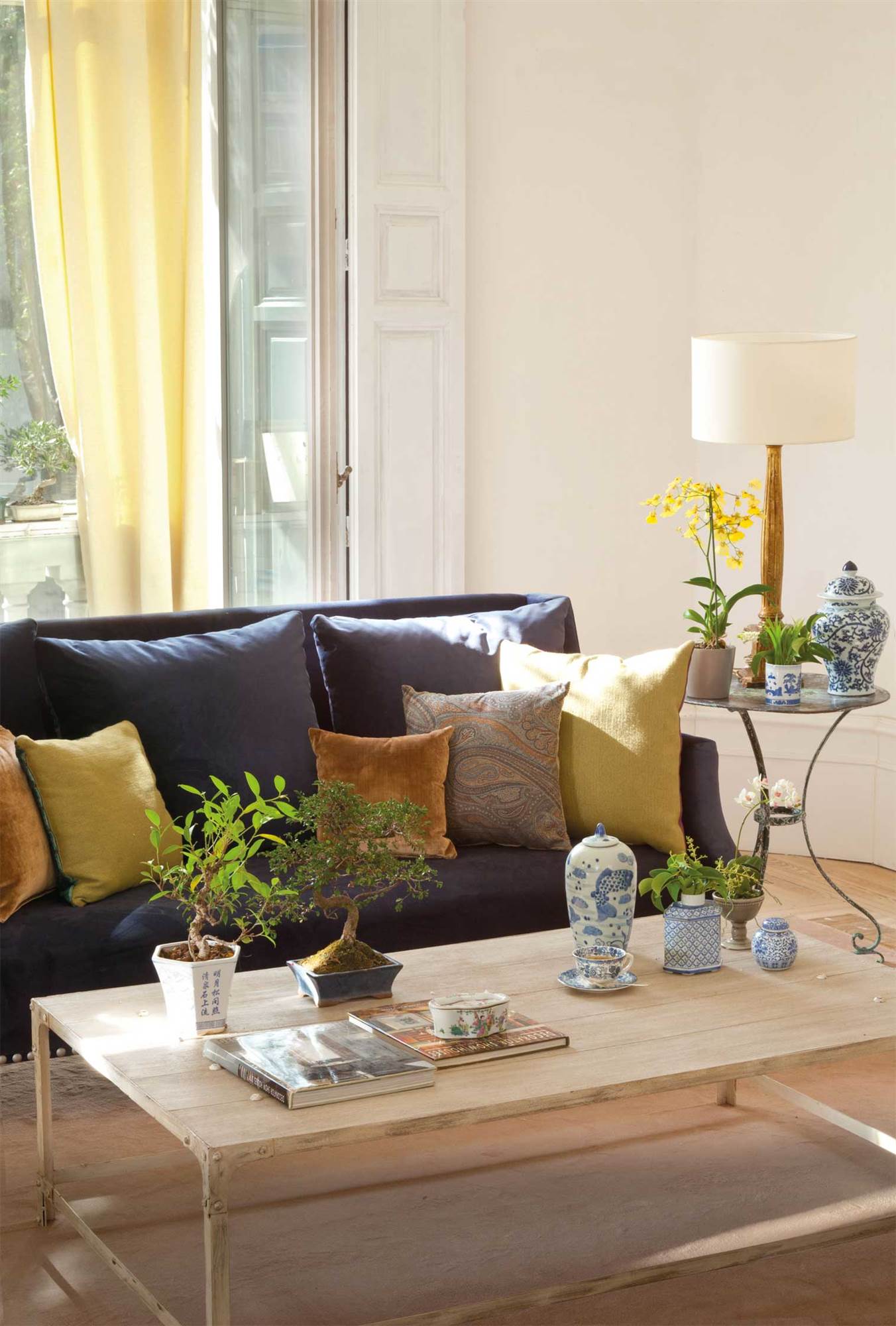 Salón con sofá azul y cojines amarillos. 