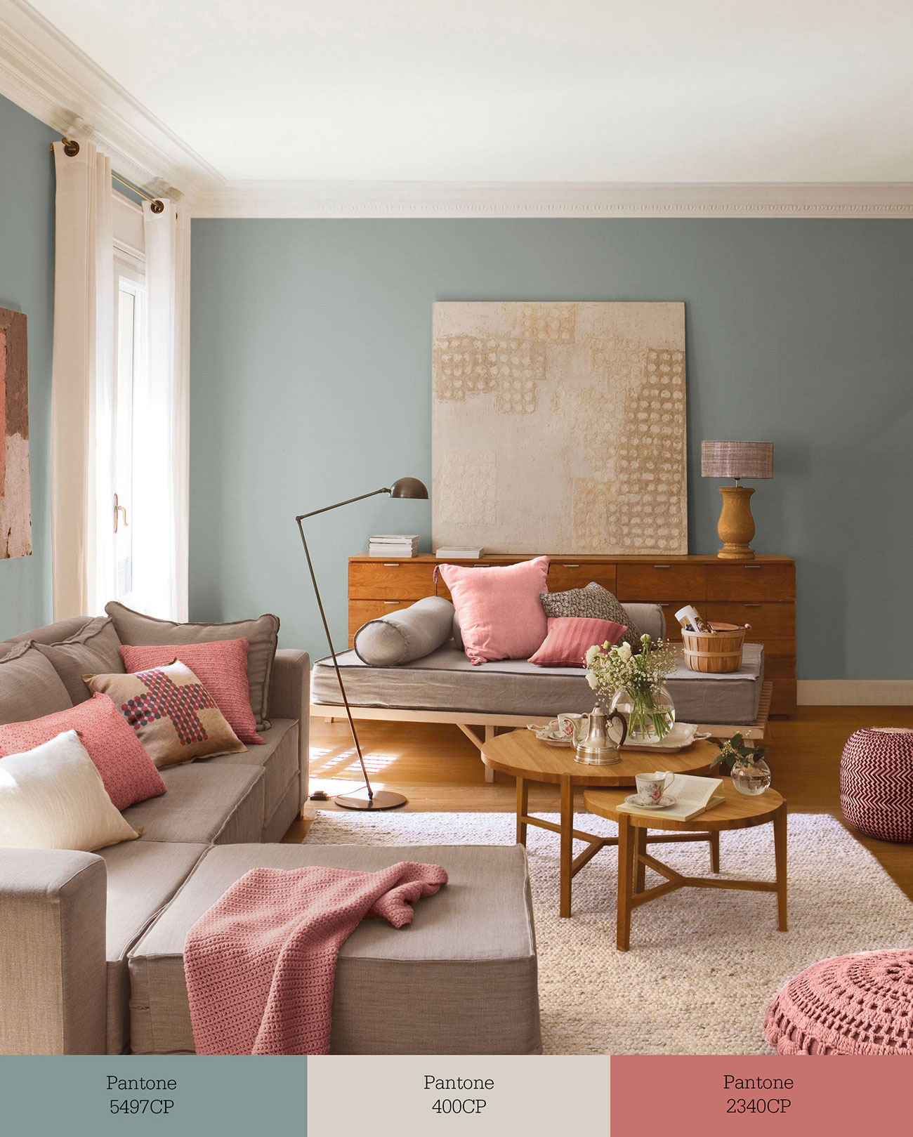 Salón con paredes pintadas de verdigris, butacas greige y detalles en rosa. 