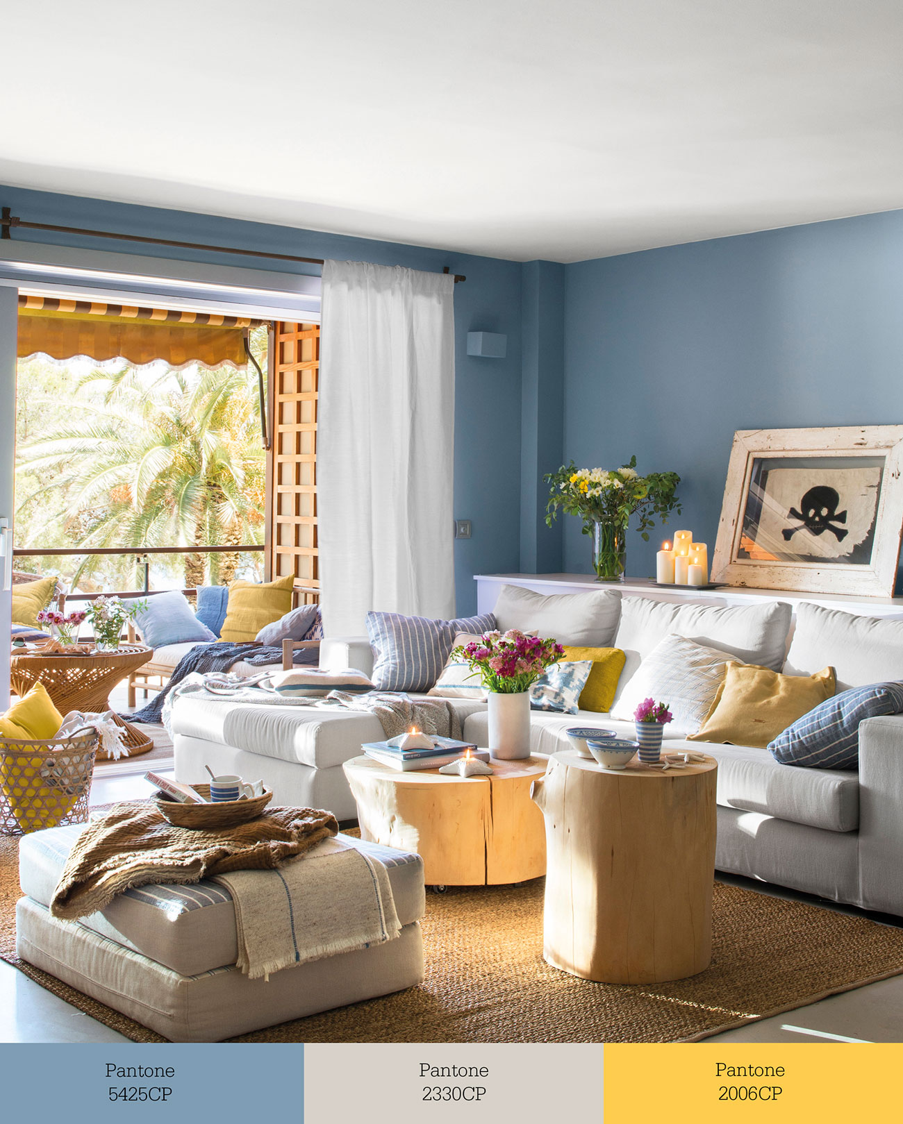 Salón con paredes azules, sofá beige y cojines de color amarillo. 