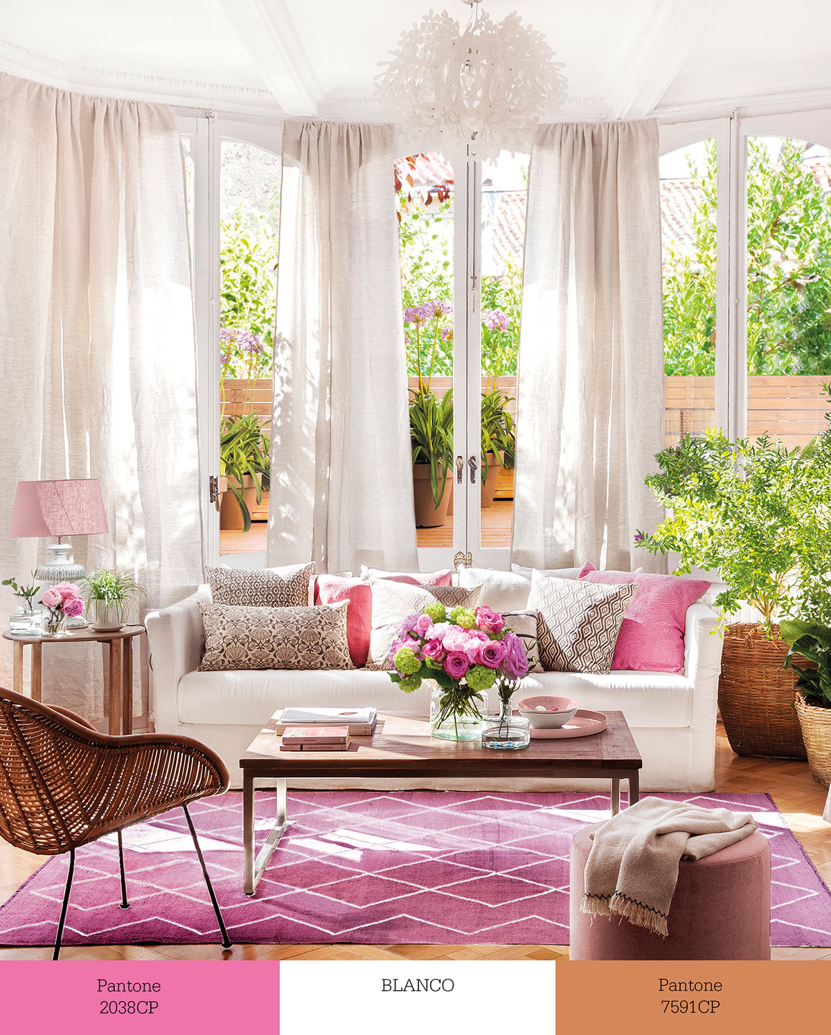Salón con sofá blanco y textiles rosas. 