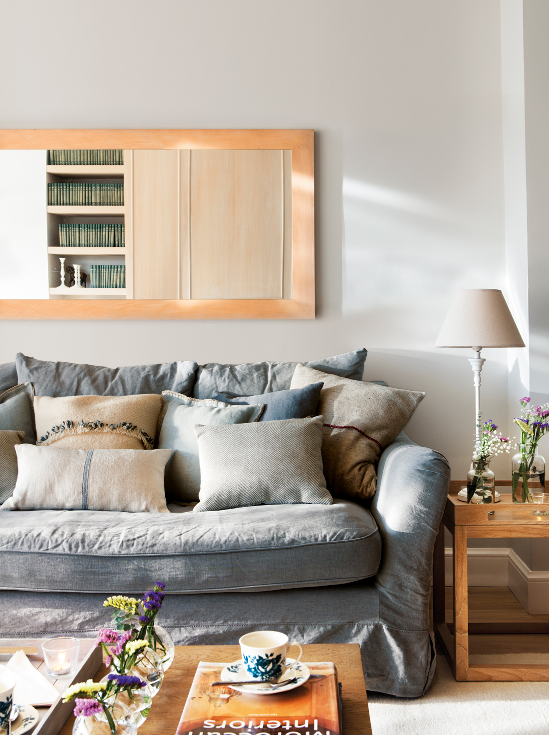 Detalle de salón con sofá gris y cuadro encima