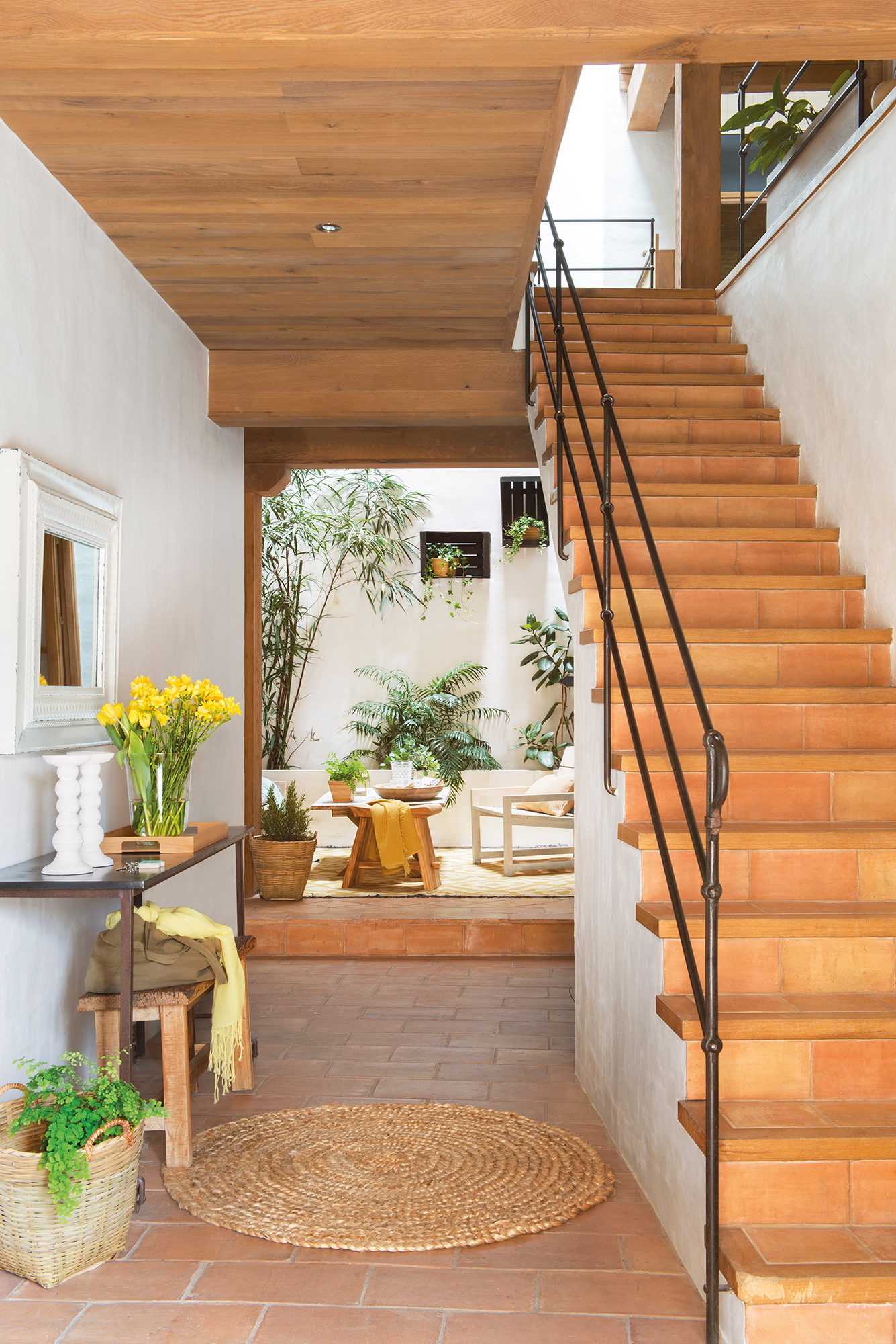 Recibidor con escalera, consola y al fondo patio