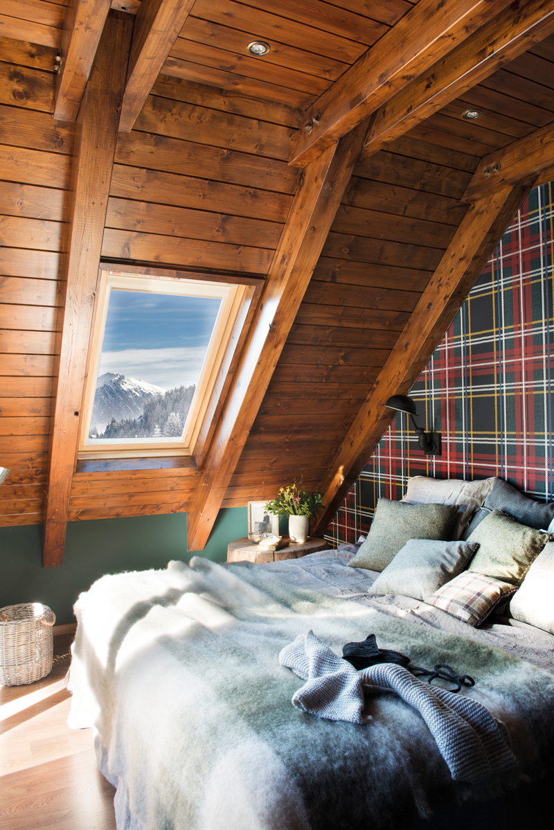 Dormitorio de casa de montaña con madera y papel pintado de tartán en la pared del cabecero