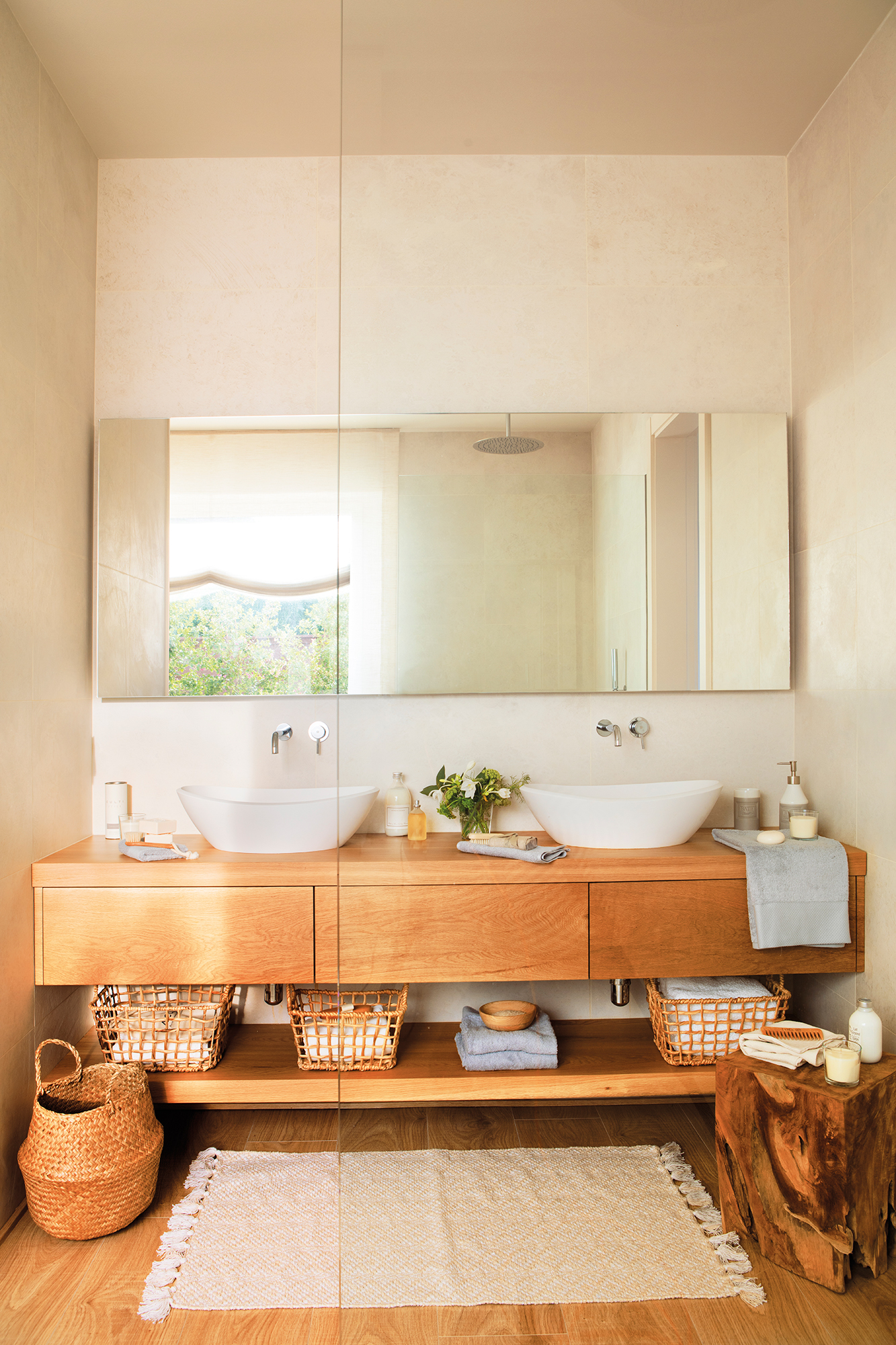 Baño con mueble de madera y espejo grande sin marco.