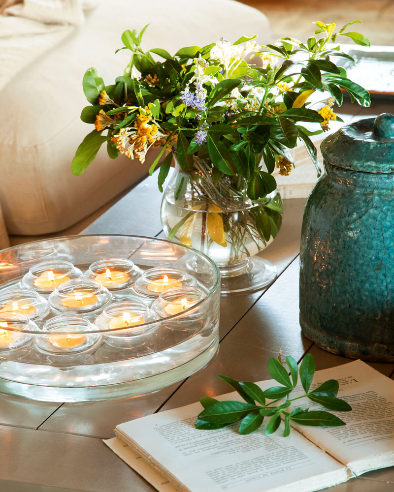 Fuente con agua y velas decorativas sobre la mesa de centro