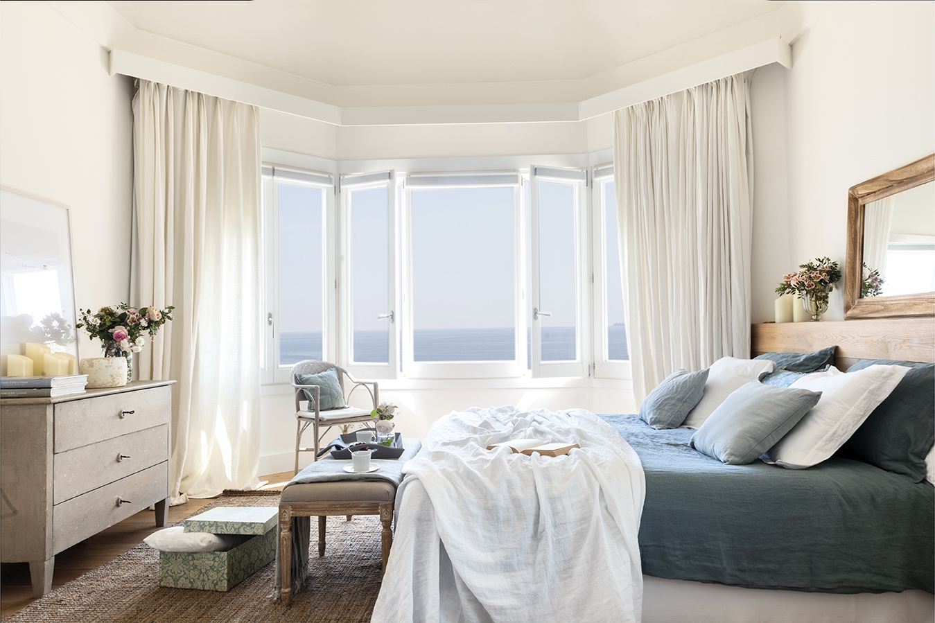 Dormitorio blanco con toques de azul y vistas al mar 