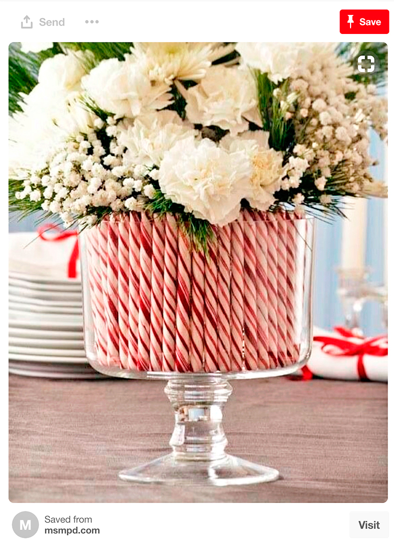 Recipiente de cristal con dulces navideños y flores balncas. Recipiente de cristal con dulces navideños y flores blancas