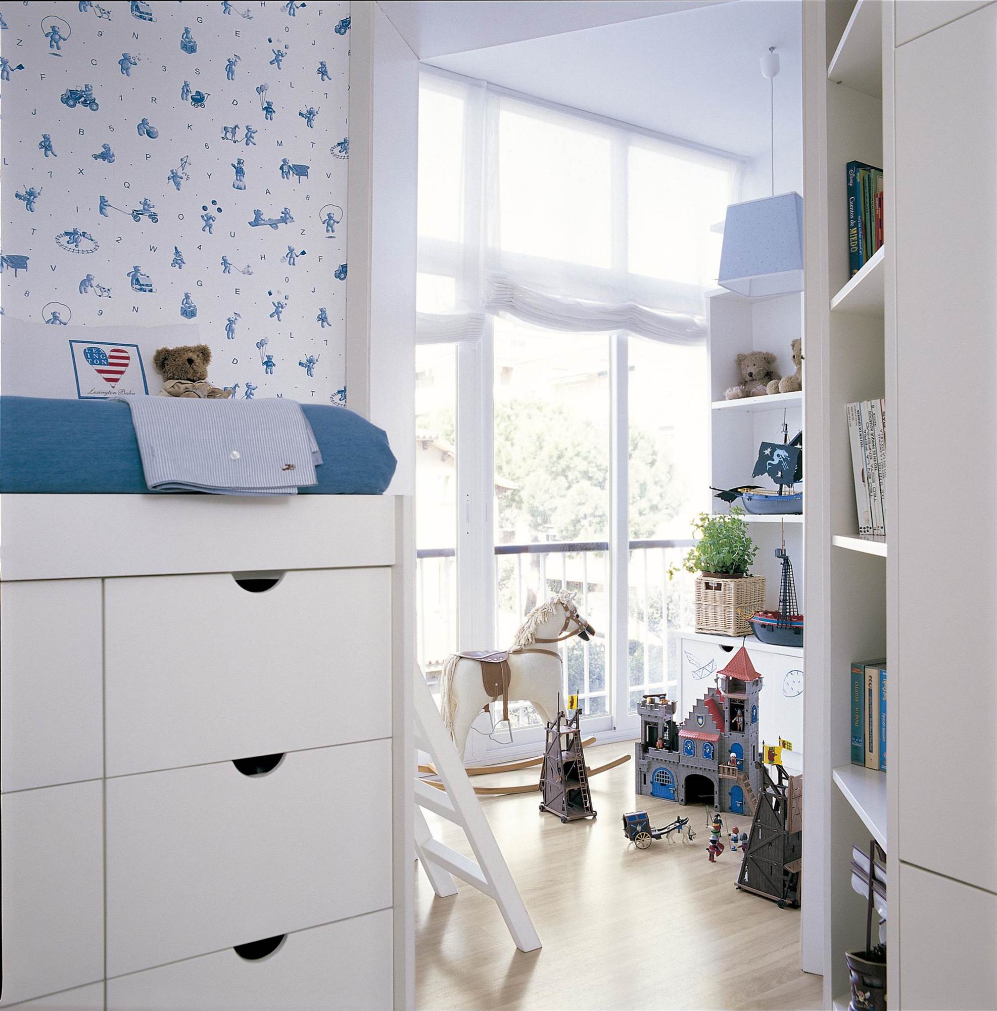 Dormitorio infantil en azul con zona de juegos, papel pintado y cama elevada.