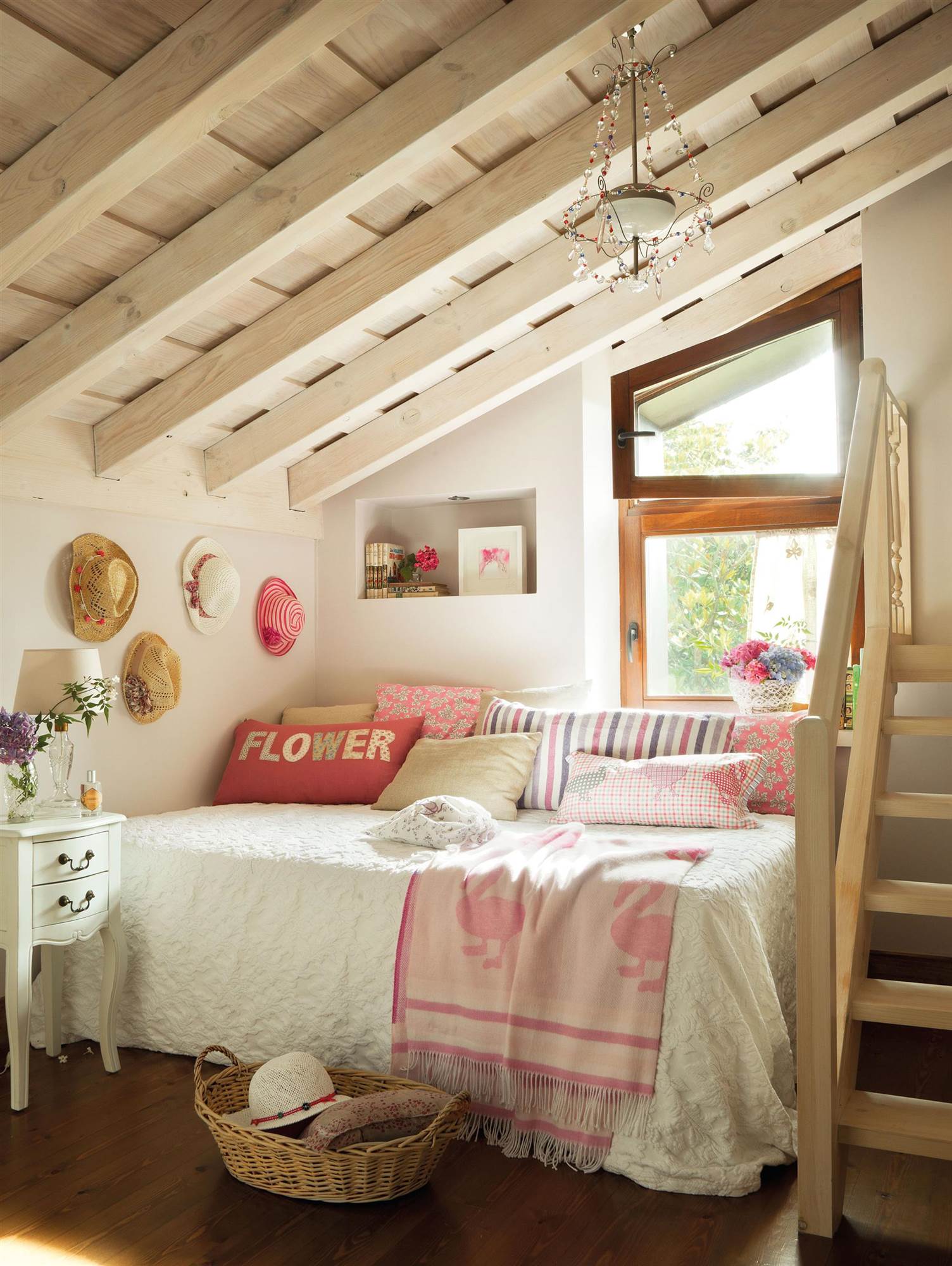 Dormitorio infantil con vigas de madera en el techo abuhardillado.