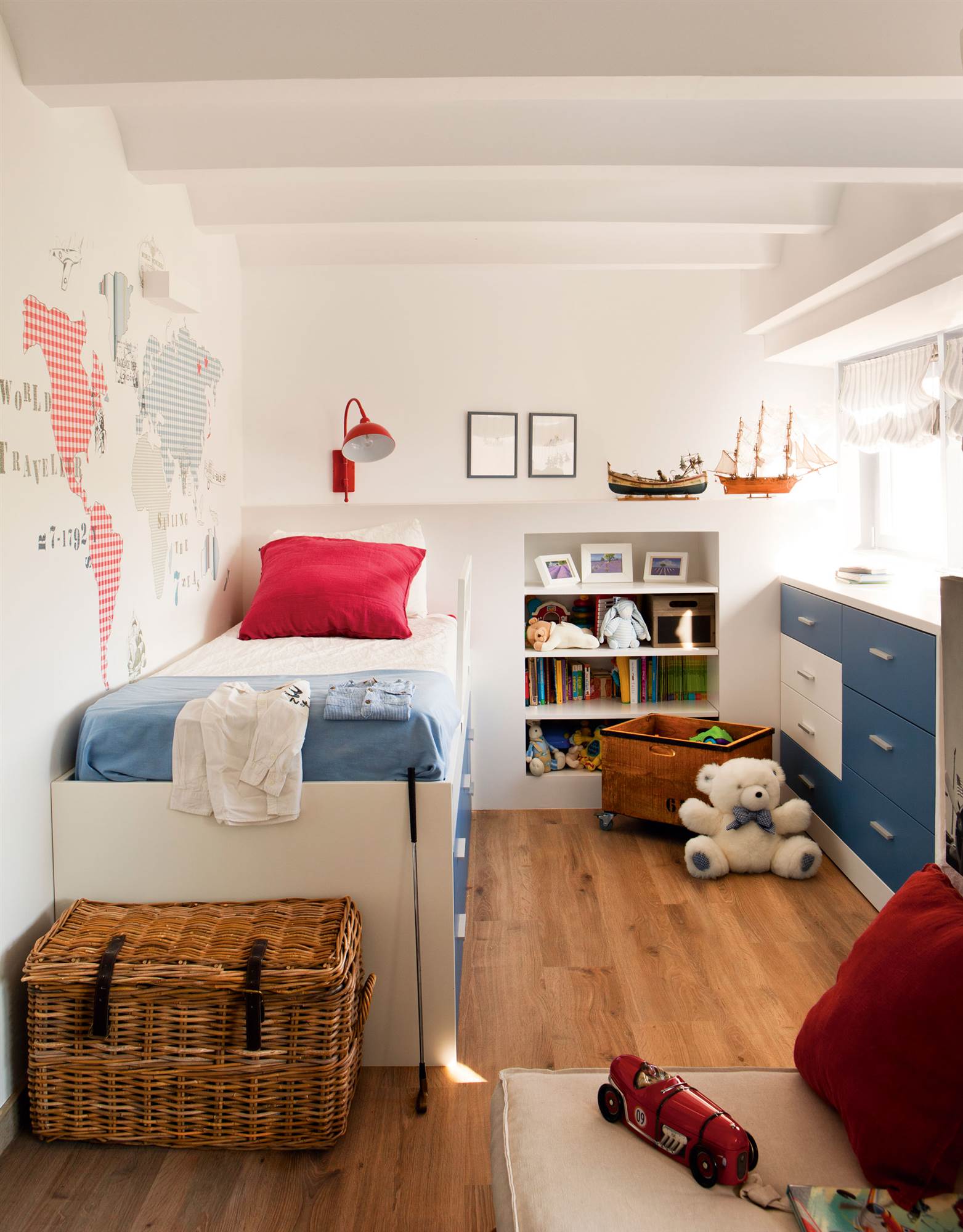 Dormitorio infantil con vinilo. enla paredy cama con cajones en azul y blanco.