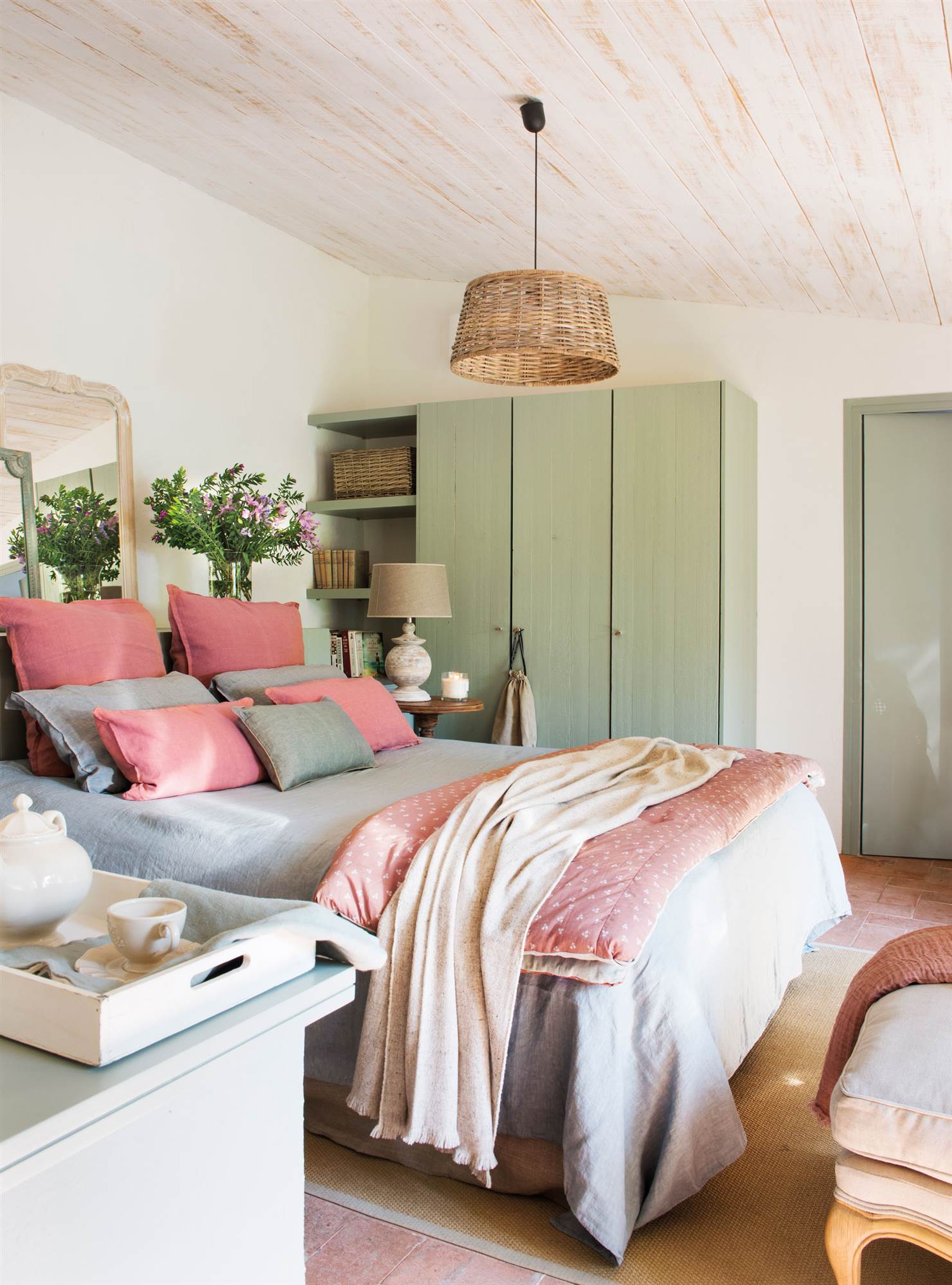 Dormitorio con armario verde y espejo como cabecero