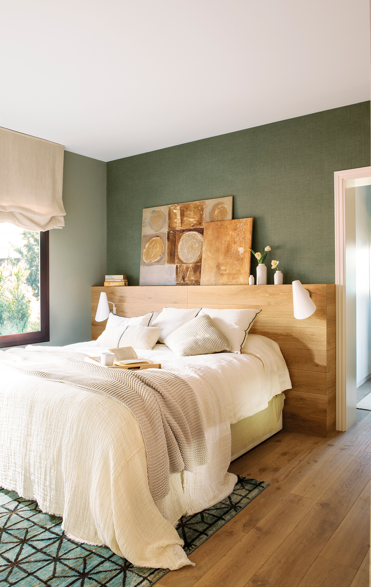Dormitorio moderno con la pared del cabecero en verde y cabecero de madera. 