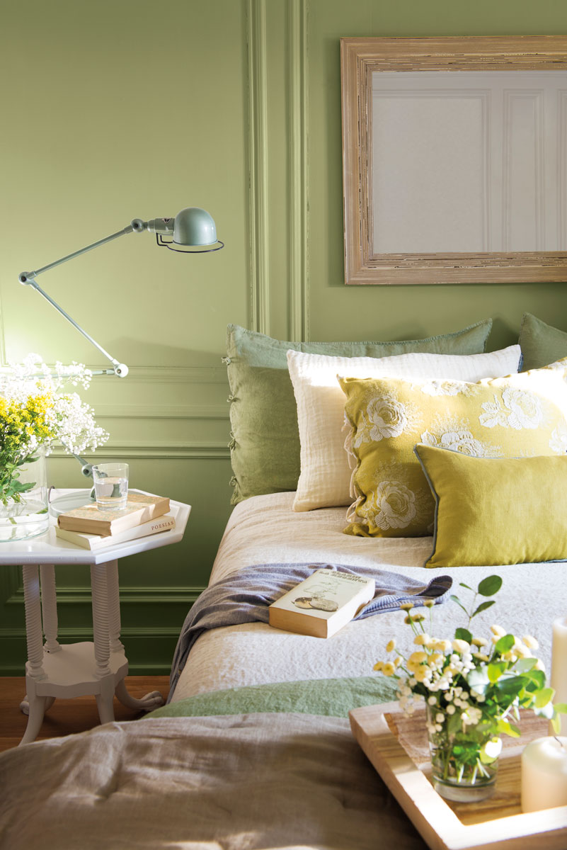 Dormitorio con pared pintada de verde y y molduras. 