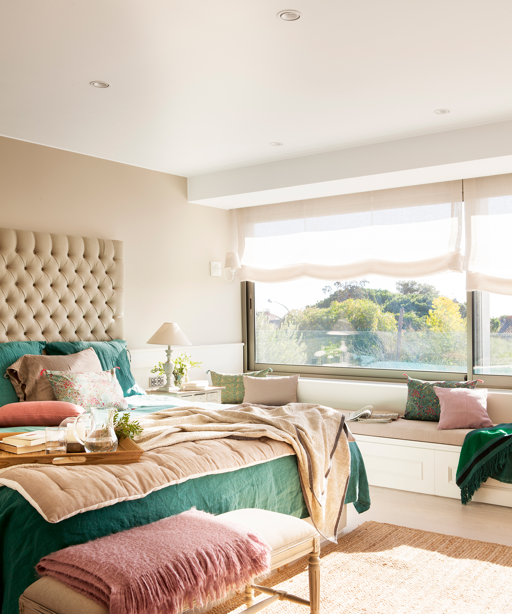 Dormitorio con cabecero maxi tapizado y gran ventanal con banco