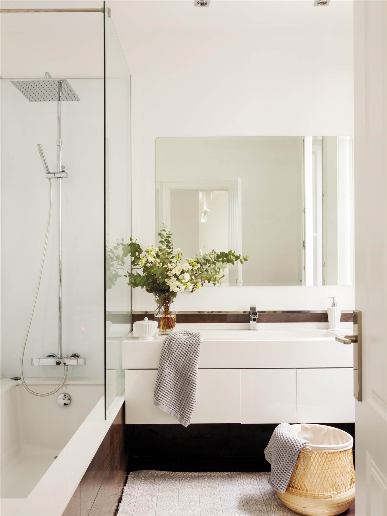 Baño moderno con mueble blanco y espejo grande. 