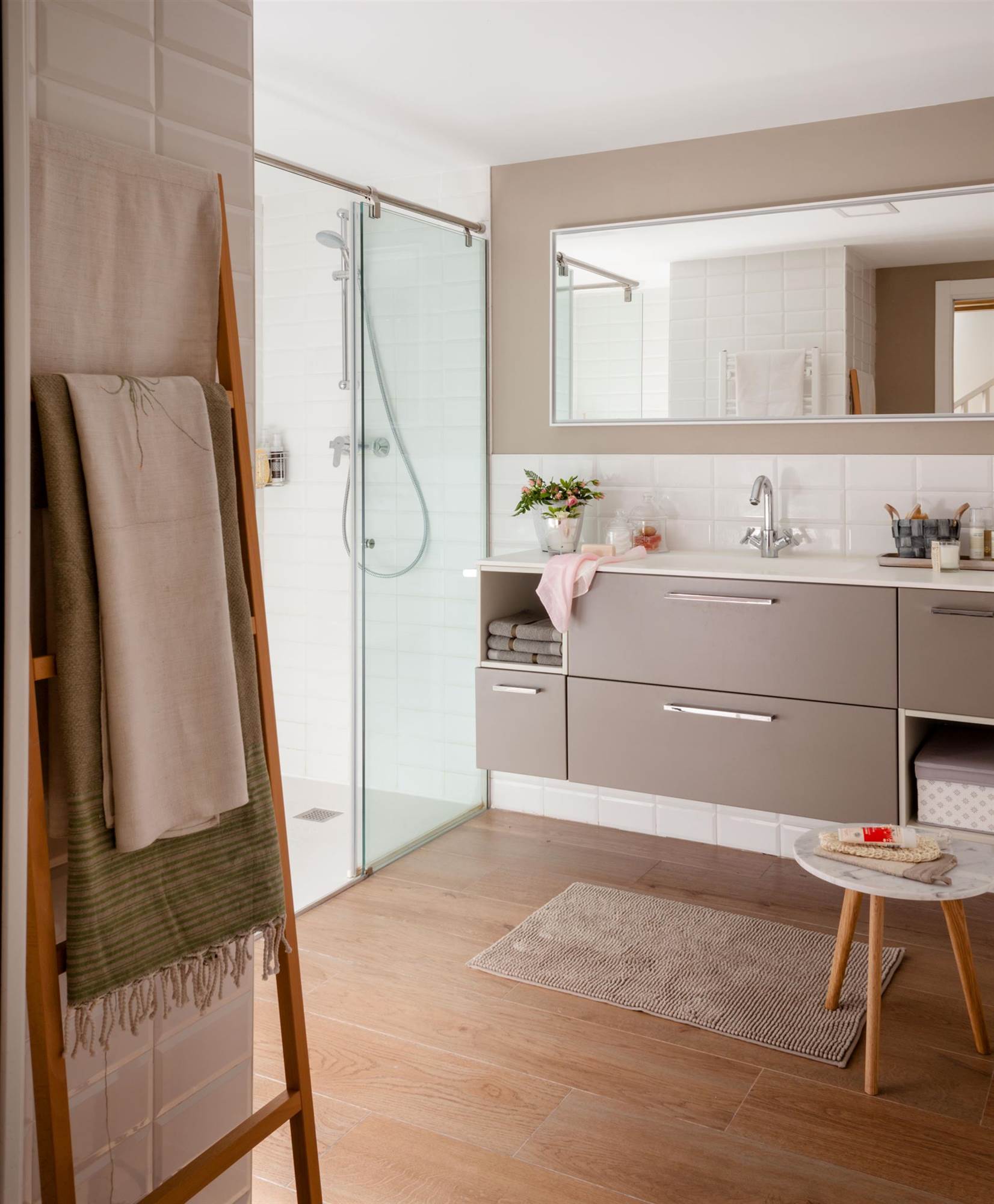 Baño con mueble de baño grande en color gris y espejo sin marco. 
