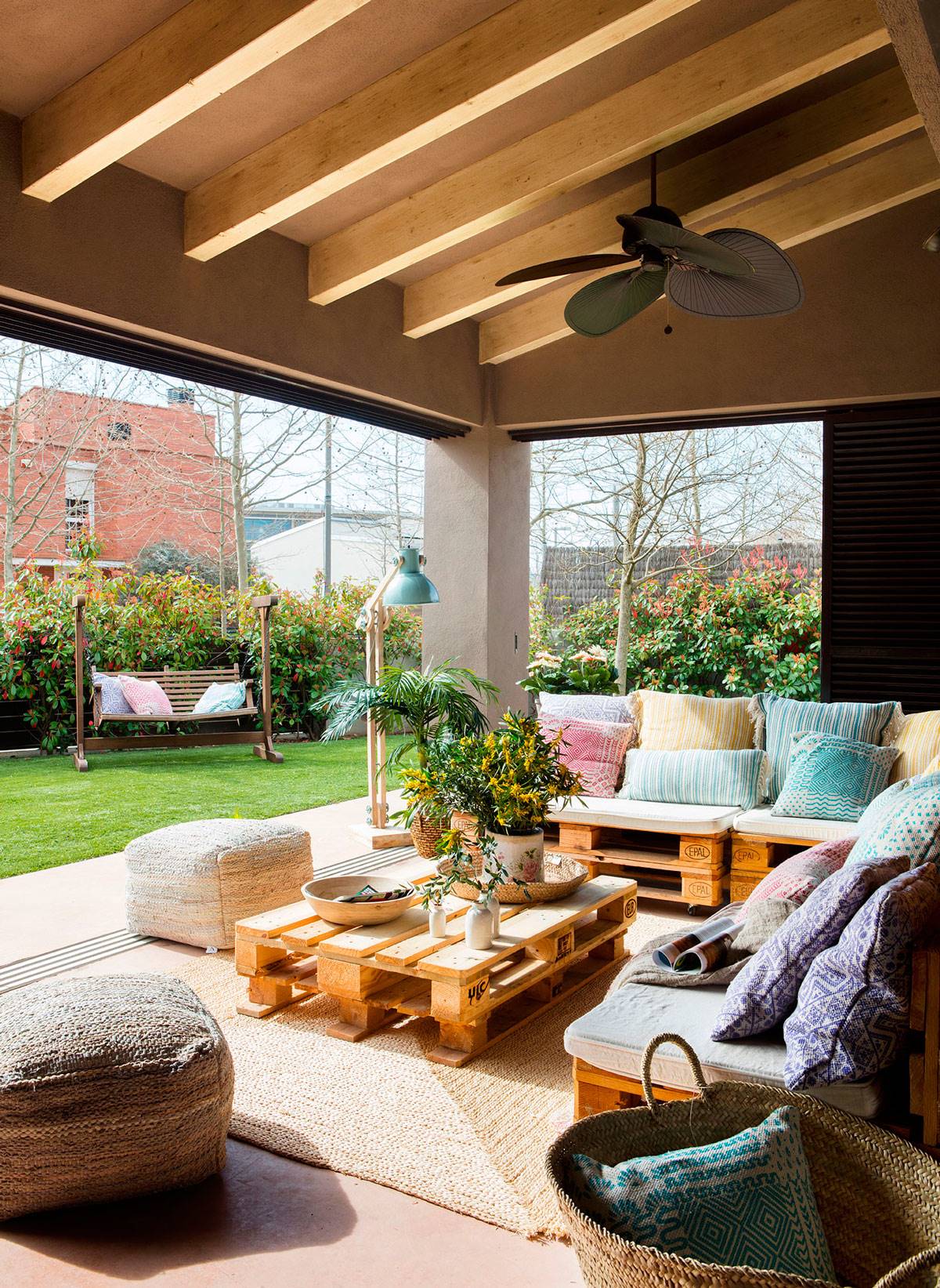 Terraza con sofás y mesa de centro hechos con palés. 