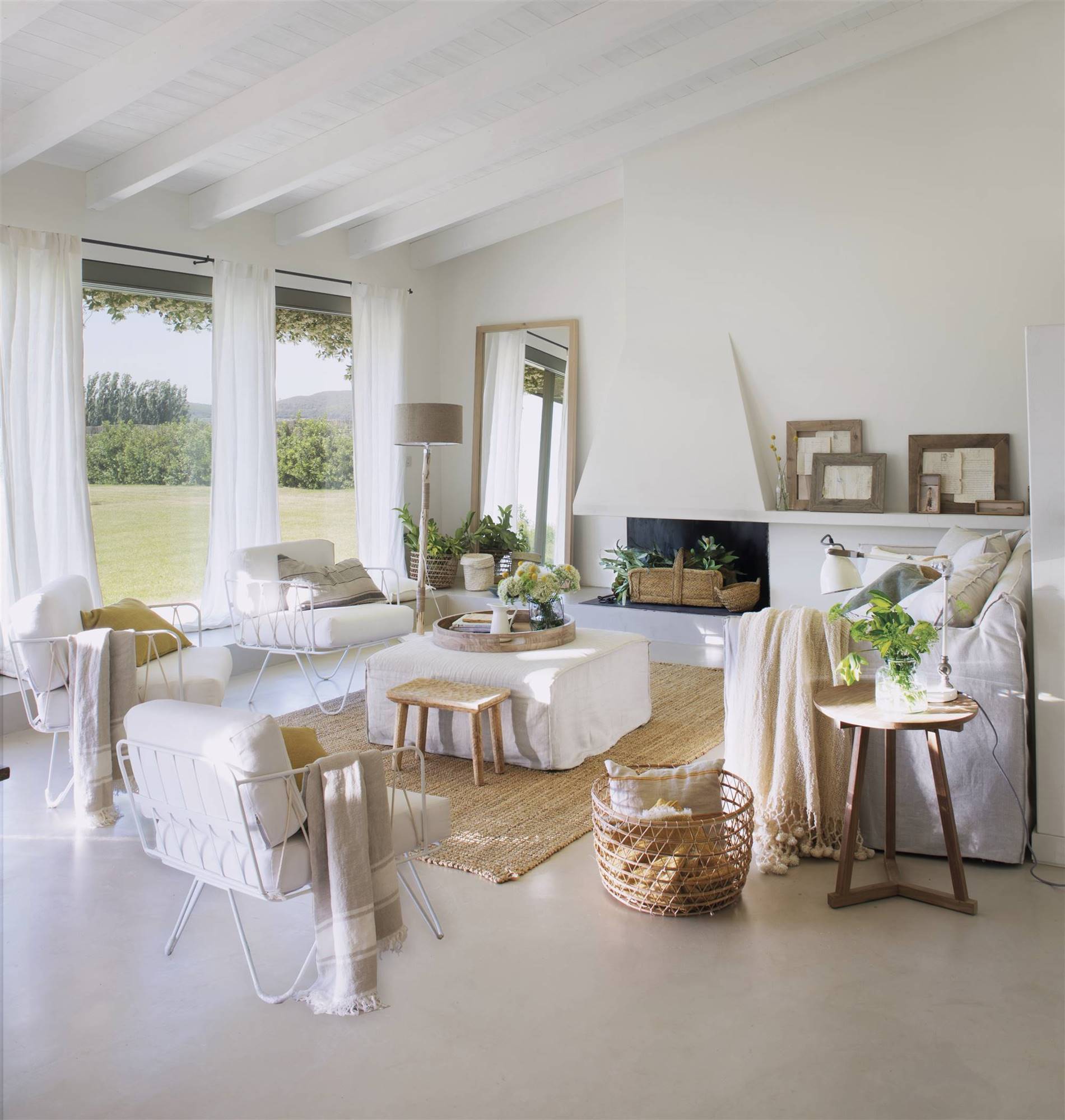 Salón luminoso con mobiliario y chimenea en blanco. 