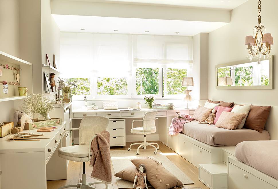 Dormitorio infantil con dos camas rosas y dos escritorios en blanco.