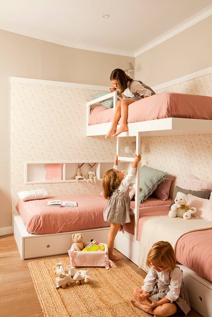 Dormitorio infantil con tres literas rosas en forma de L.