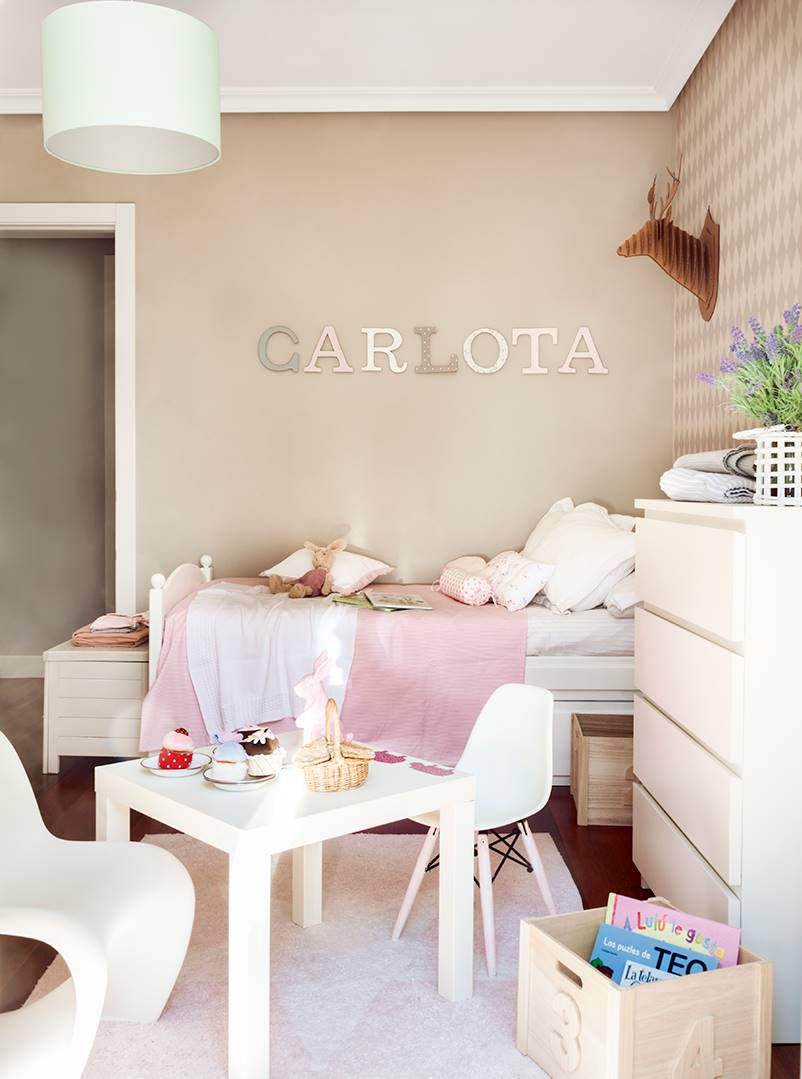 Una habitación infantil con el nombre de la niña "Carlota" en la pared.