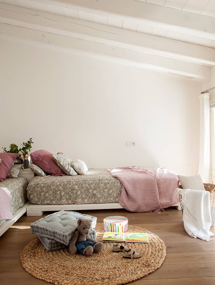 Dormitorio infantil básica con dos camas en L y alfombra de fibras.