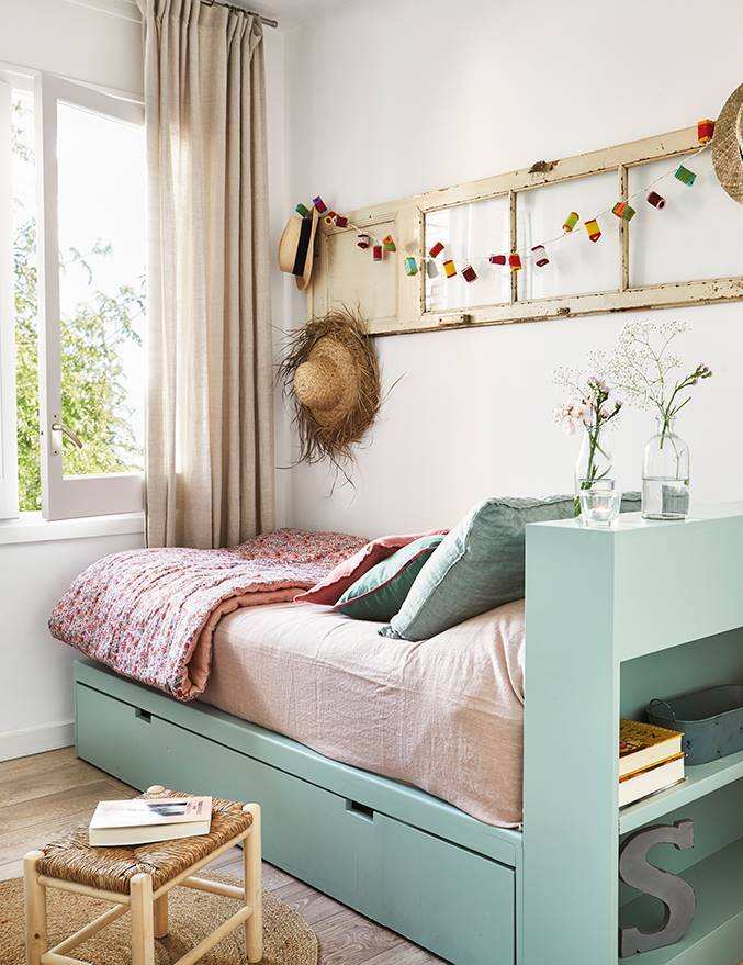 Una habitación infantil con una estructura de cama con cabecero con almacenaje.