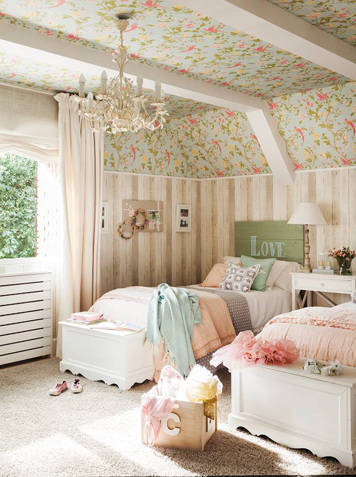 Una habitación infantil con mezcla de papeles pintados y bancos para almacenaje a pie de cama.